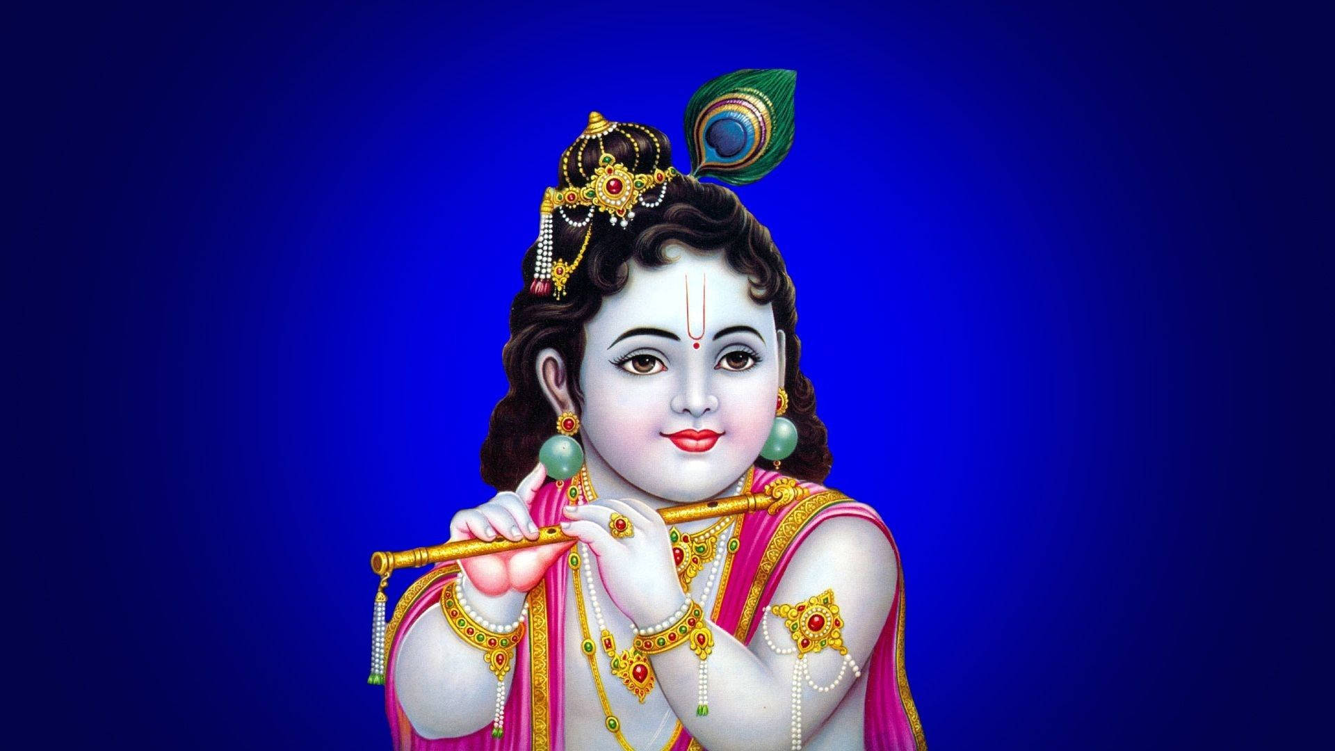 Hindu God 桌布 壁紙 — 一個戴著孔雀羽毛皇冠的神聖小孩在深藍色背景前吹奏長笛，飾有金色珠寶和粉紅色服裝。