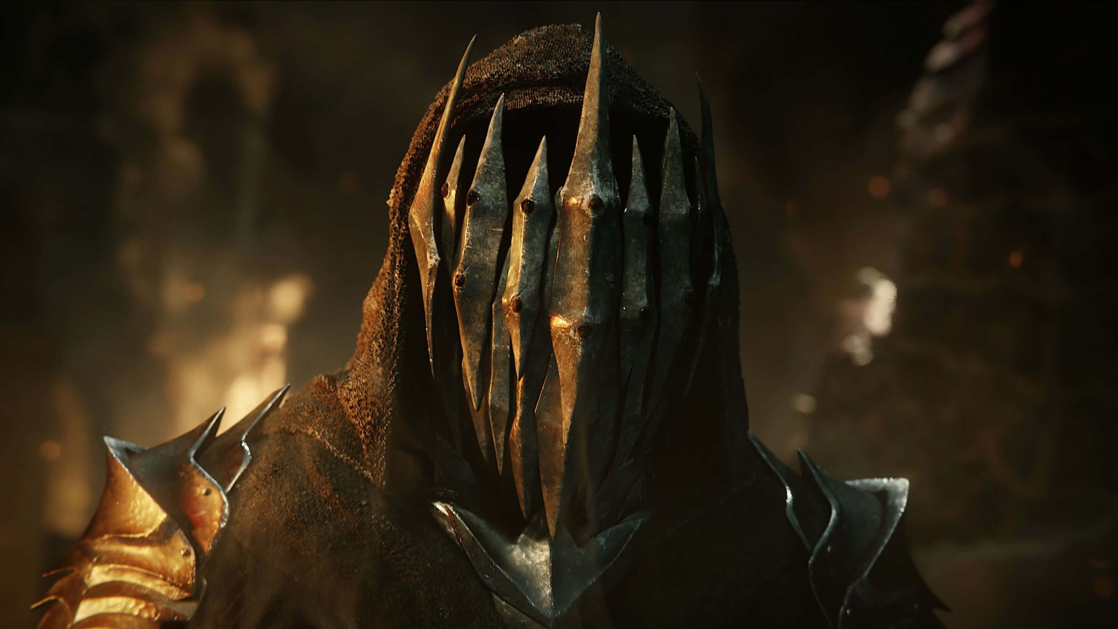 4K Shadow Of War 桌布 壁紙 — 一個戴著尖刺頭盔和兜帽的威脅性裝甲人物，在昏暗、煙霧瀰漫的環境中隱現。