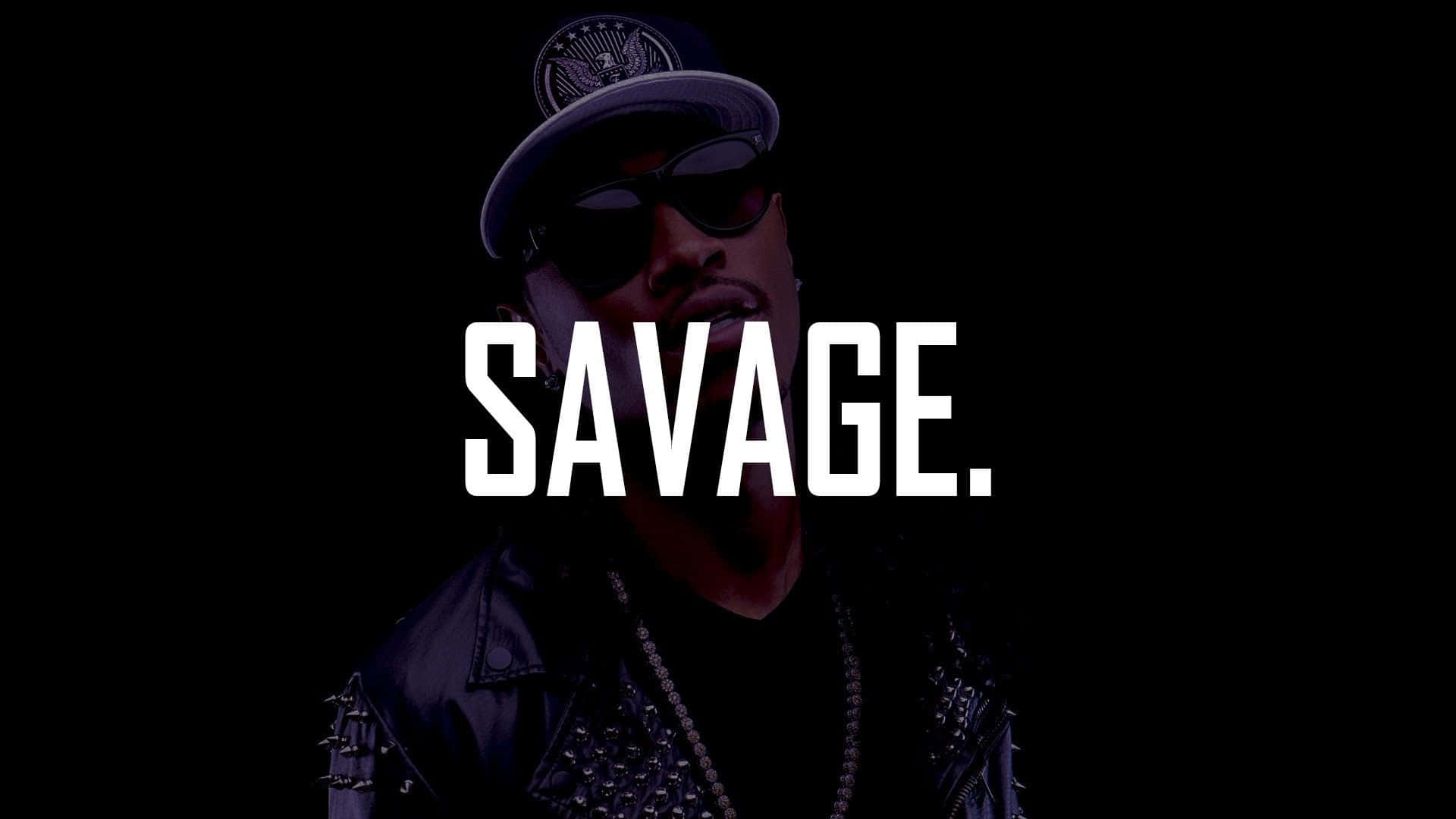 savage 桌布 壁紙 — 一個戴著帽子和太陽眼鏡的男人，在黑色背景上以粗體白色文字寫著「SAVAGE」，他正強烈地凝視著。