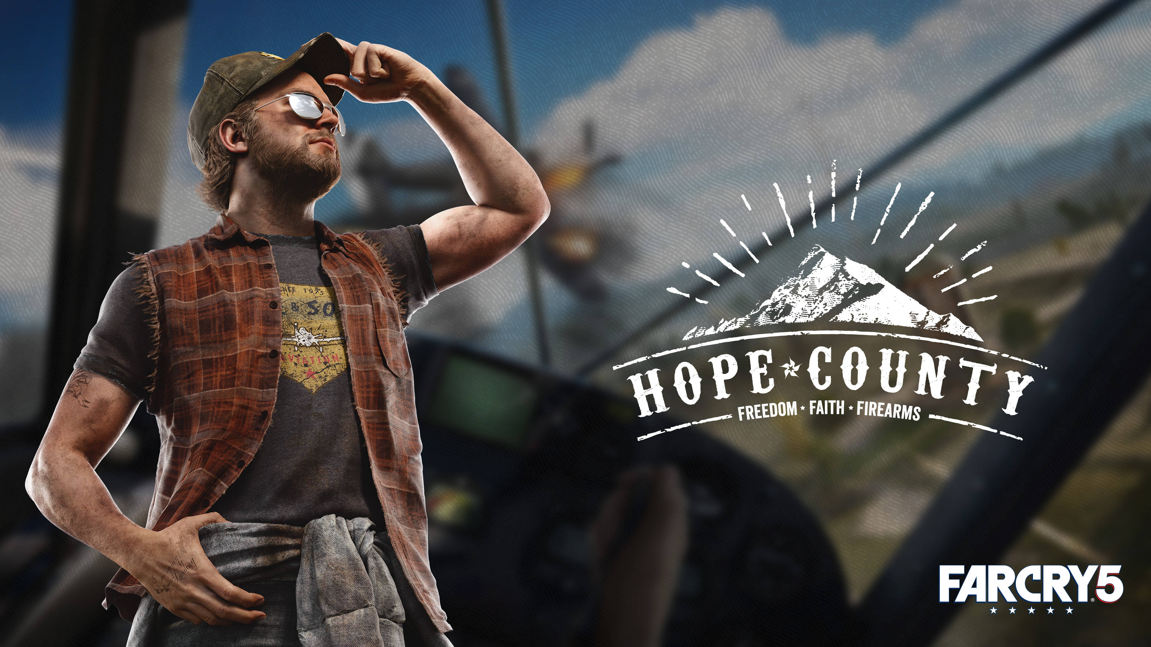 Far Cry 5 桌布 壁紙 — 一個戴著帽子和格紋背心的粗獷男人，自信地站在山景和復古飛機的背景前。
