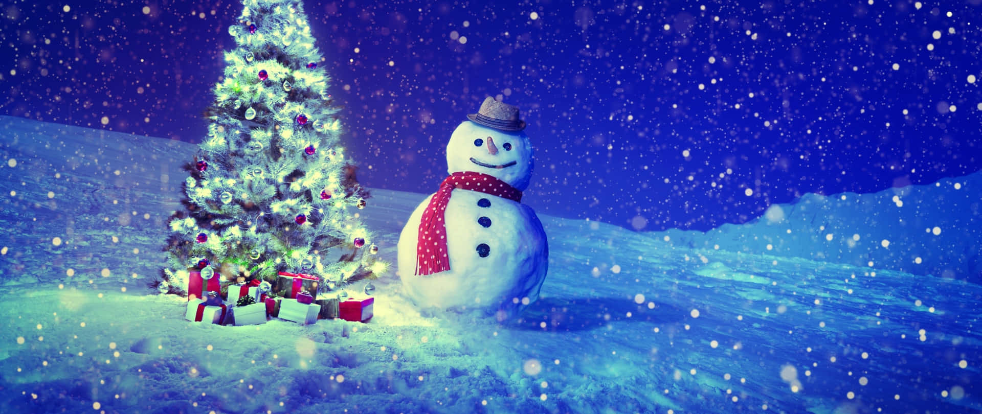 壁紙 — 一個戴著帽子和紅色圍巾的快樂雪人，站在一個有禮物、亮著燈的聖誕樹旁，夜晚雪花飄落。