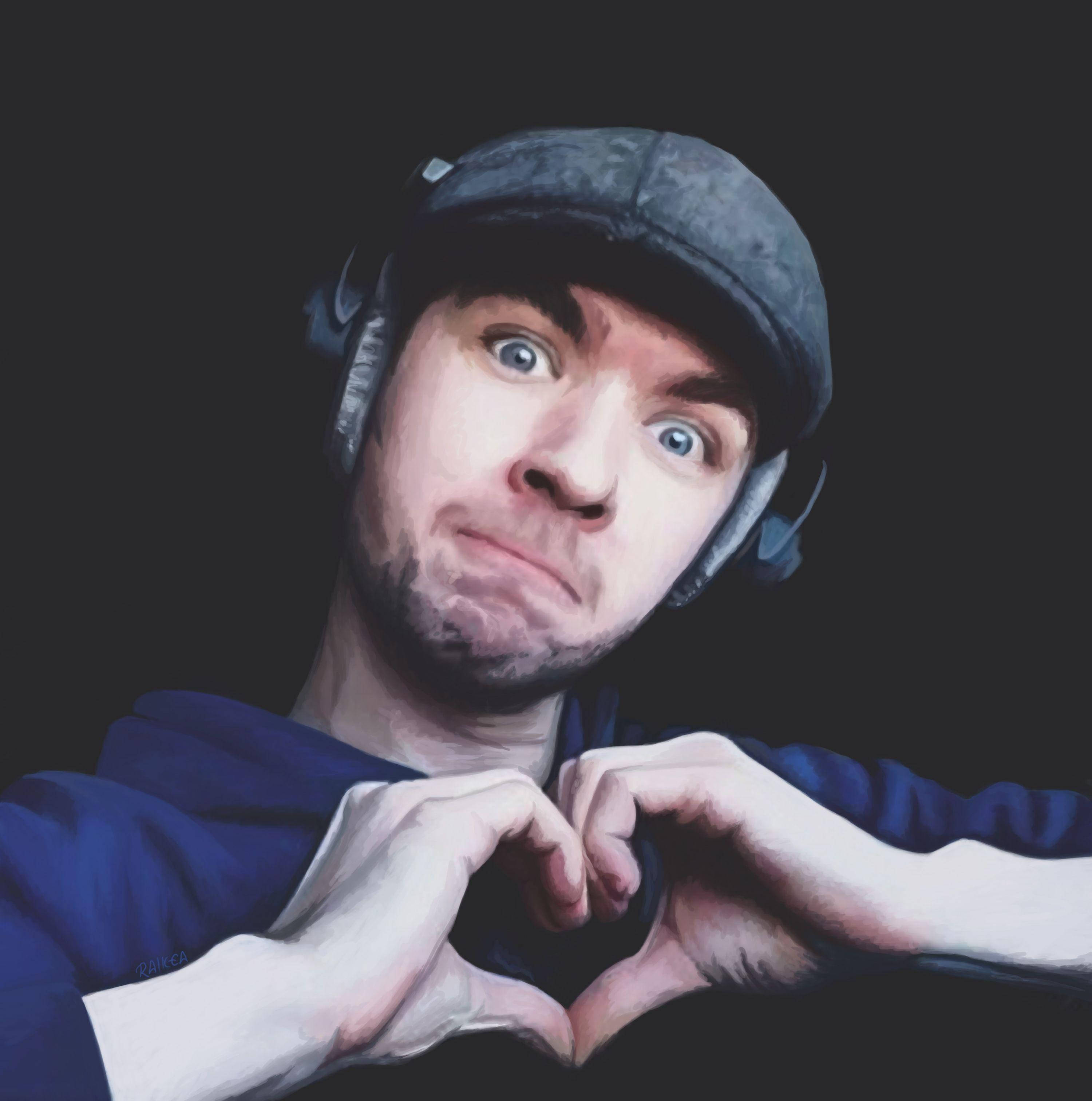 Jacksepticeye 桌布 壁紙 — 一個戴著帽子和耳機的男人在深色背景前用手比出心形。