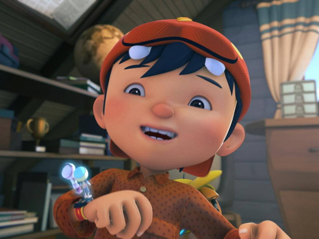 Boboiboy 桌布 壁紙 — 一個戴著橙色帽子的開心動畫男孩在雜亂的木房間裡拿著一個發光的小工具。