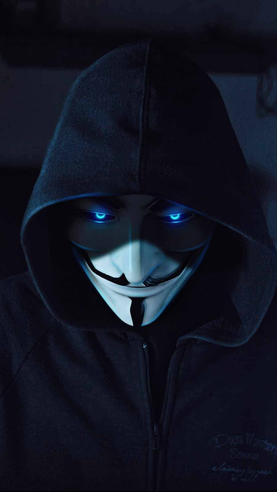 Mask 桌布 壁紙 — 一個戴著深色連帽衫的蒙面人物，在昏暗燈光下戴著白色蓋伊·福克斯面具，眼睛發出藍光。