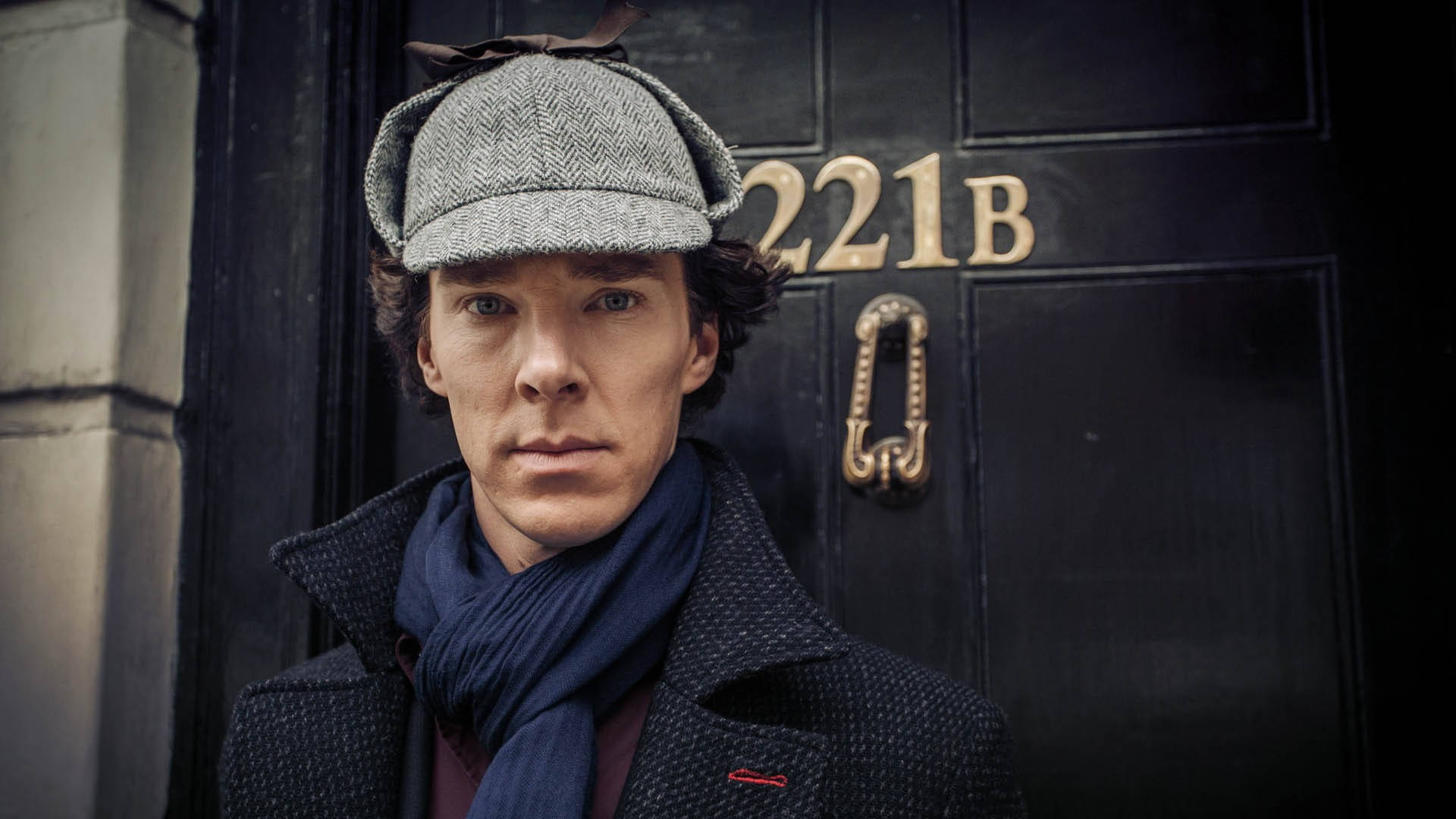 Sherlock 桌布 壁紙 — 一個戴著獵鹿帽和圍巾的男人莊嚴地站在標誌性的221B貝克街門前。