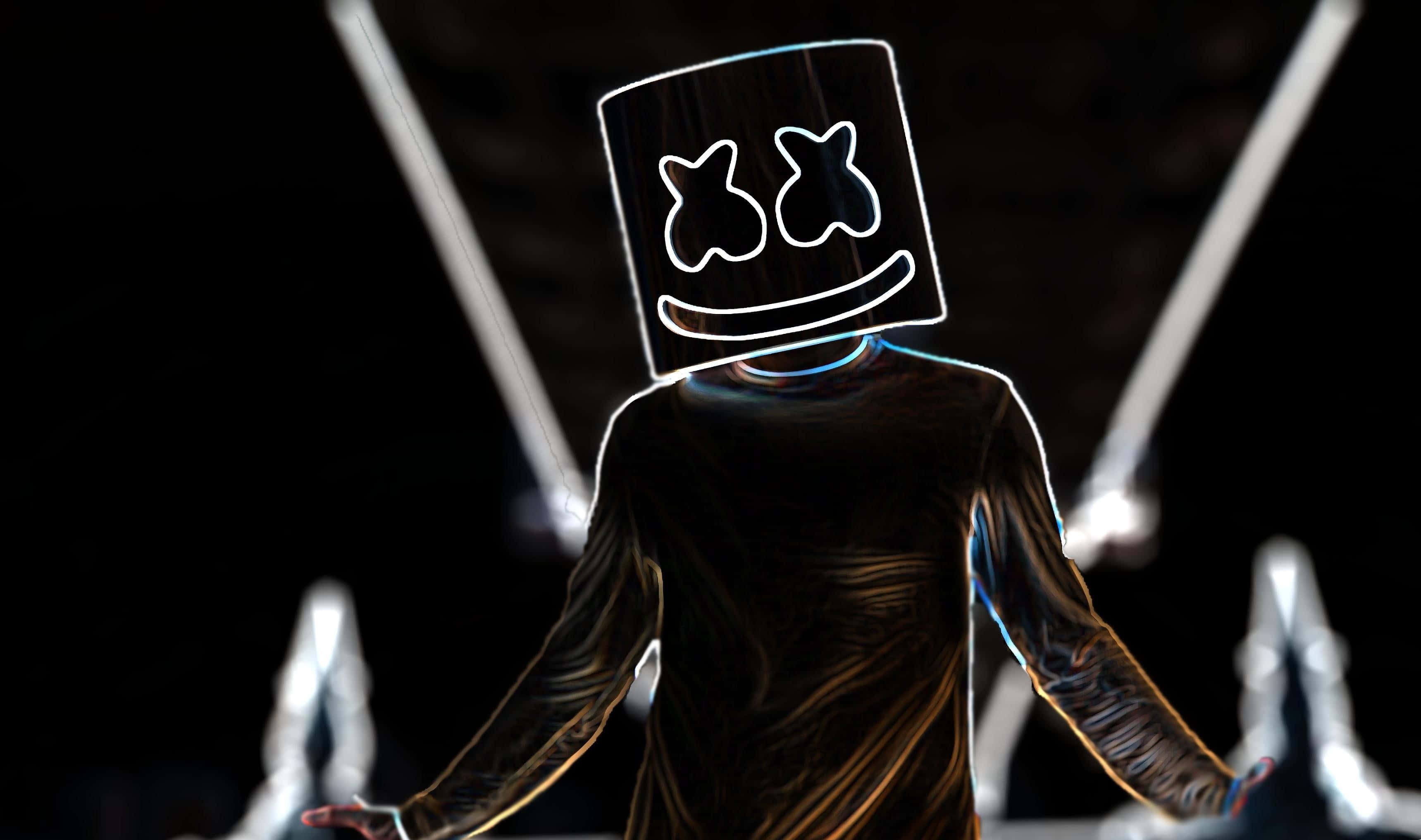 Marshmello 動態圖 桌布 壁紙 — 一個戴著發光棉花糖面具的人物在黑暗背景下站在舞台中央，被明亮的聚光燈照射。