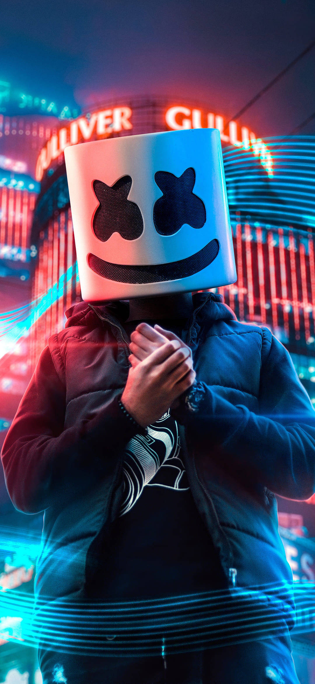 marshmello iPhone 桌布 壁紙 — 一個戴著發光棉花糖面具的人站在充滿鮮豔紅藍霓虹燈光的城市景觀中。
