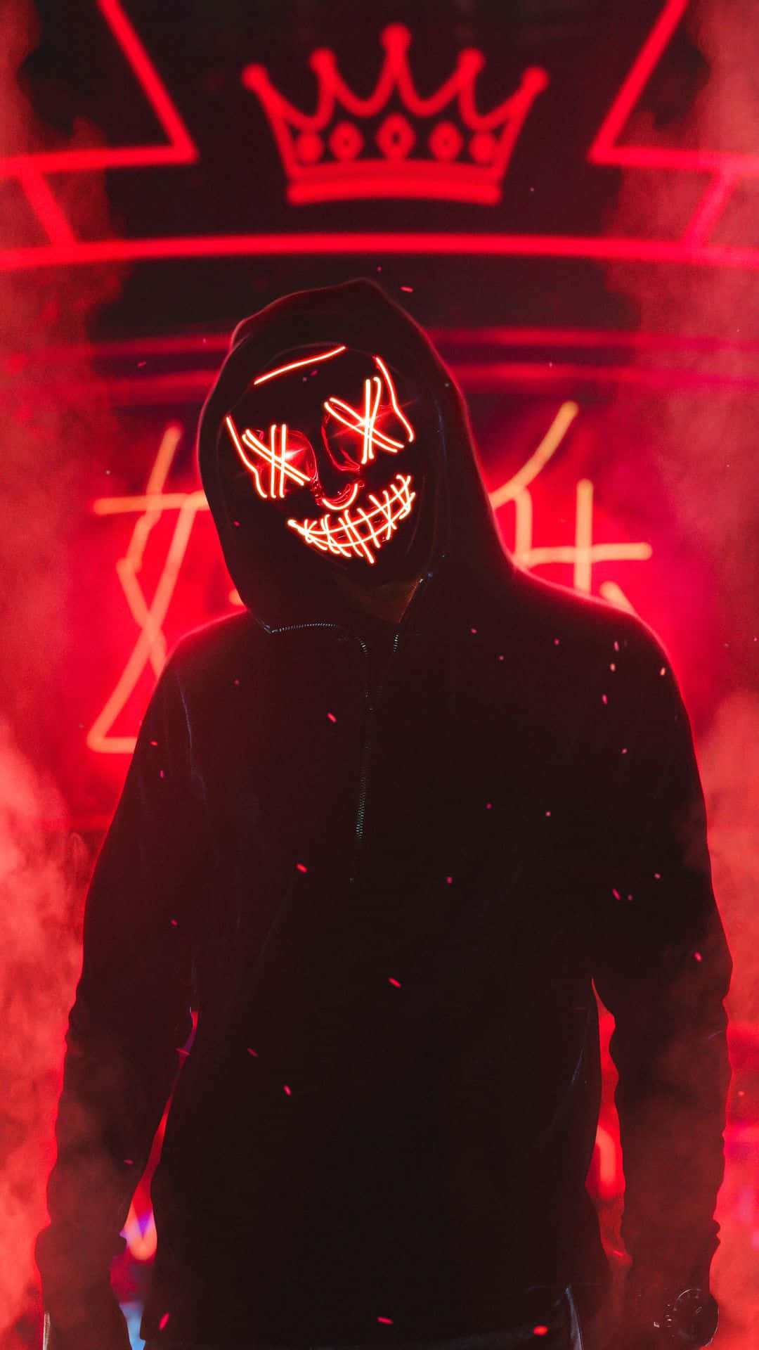 Mask 桌布 壁紙 — 一個戴著發光紅色LED骷髏面具的兜帽人物，站在煙霧瀰漫的黑暗中，下方是一個霓虹皇冠標誌。