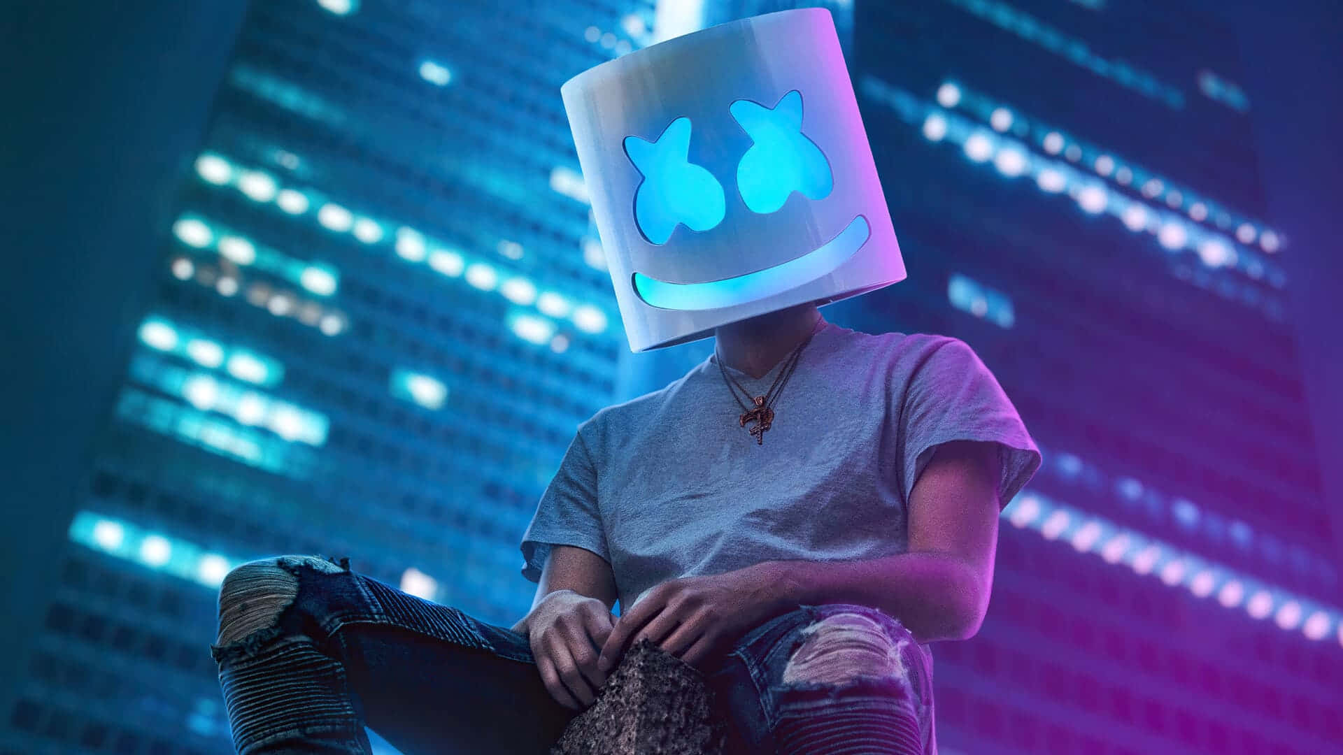 Marshmello 動態圖 桌布 壁紙 — 一個戴著發光藍色棉花糖頭盔的人坐在夜晚霓虹燈閃爍的城市景觀前。