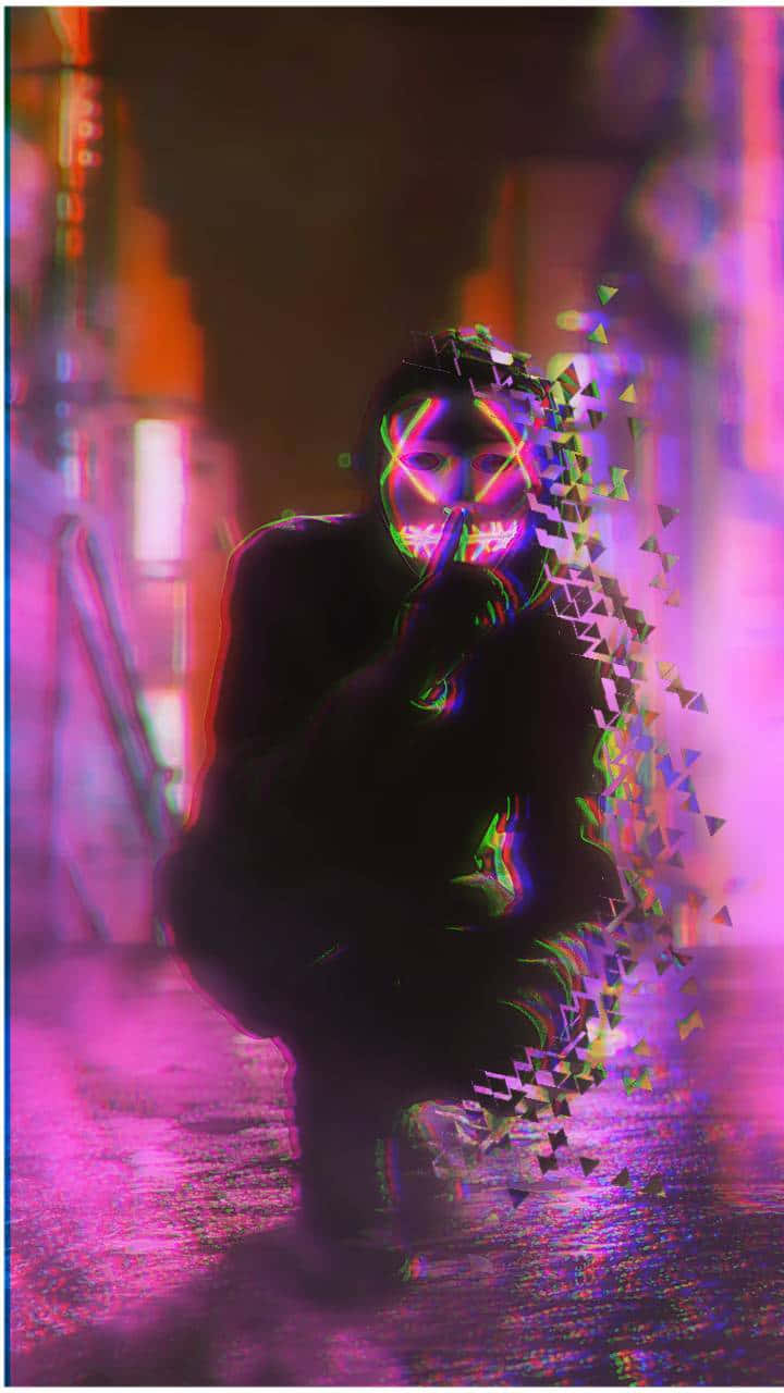Neon Mask 桌布 壁紙 — 一個戴著發光霓虹面具的身影蹲在濕漉漉的賽博龐克小巷中，在鮮豔的粉紅和紫色燈光下分解成像素化三角形。