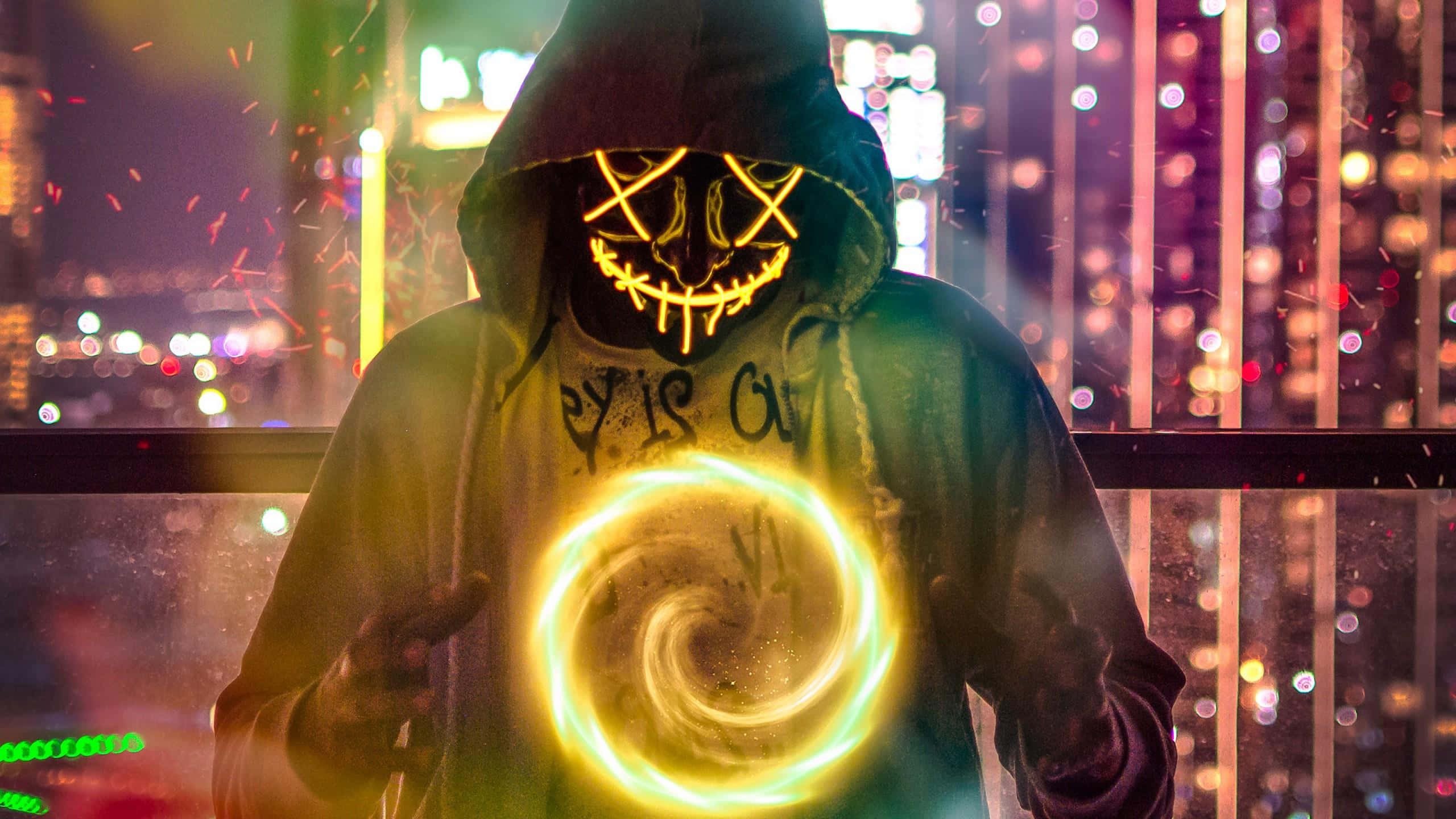 Mask 桌布 壁紙 — 一個戴著發光面具的兜帽身影，在霓虹燈照亮的城市夜景中，引導著一個旋轉的金色能量球。
