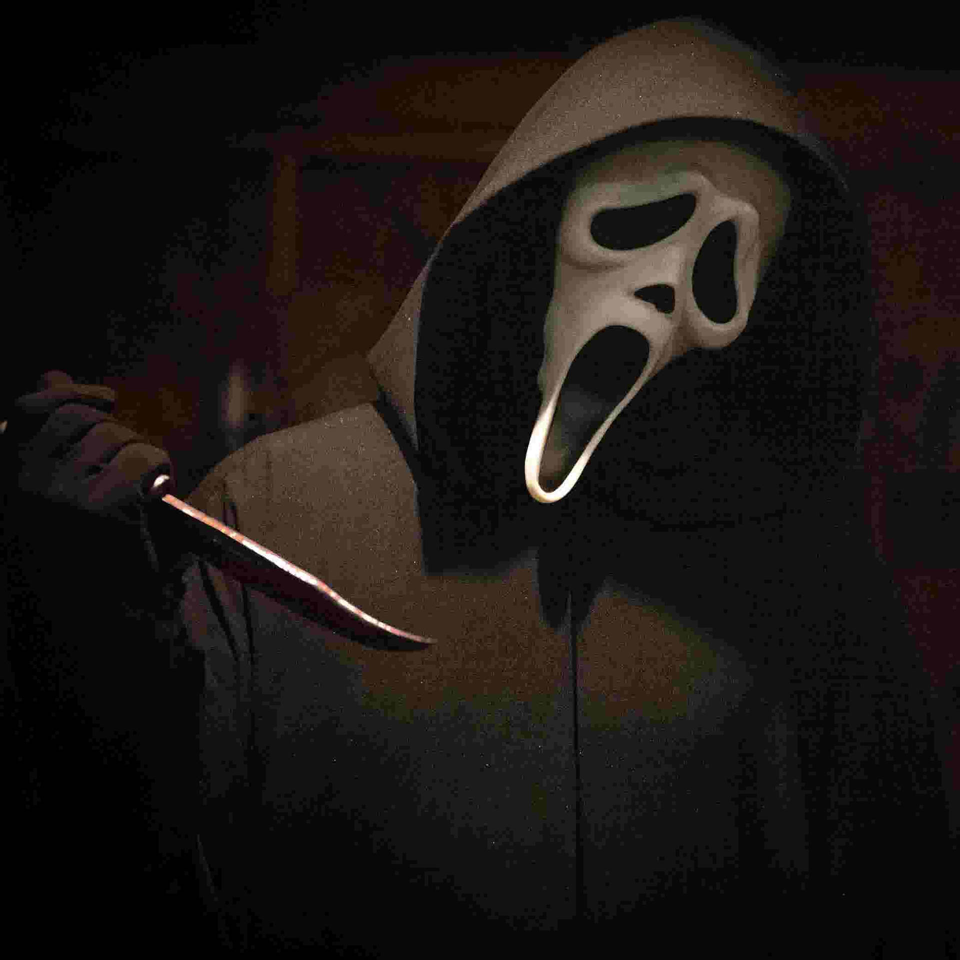 Mask 桌布 壁紙 — 一個戴著白色尖叫面具的兜帽人物在黑暗、顆粒狀的環境中拿著一把刀。