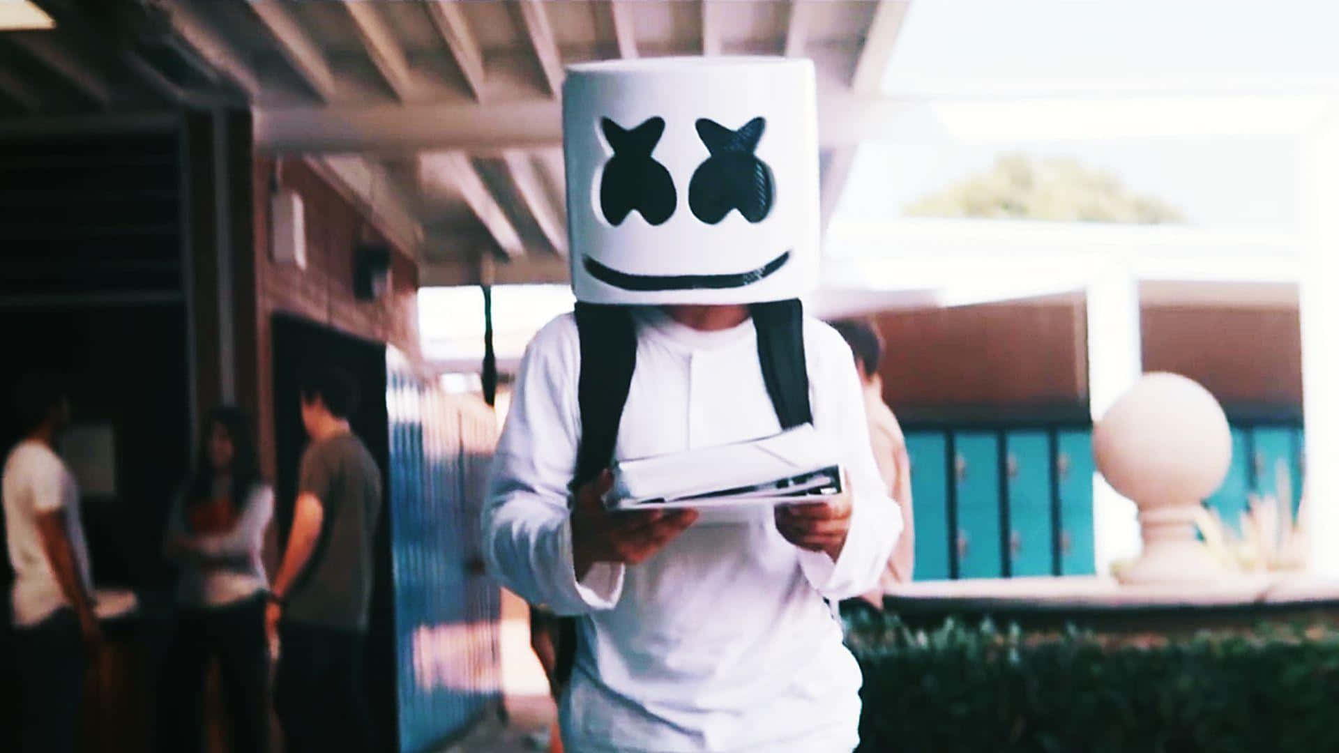 Marshmello 動態圖 桌布 壁紙 — 一個戴著白色棉花糖頭盔、有黑色眼睛和笑容的人，在有蓋通道下拿著平板電腦。