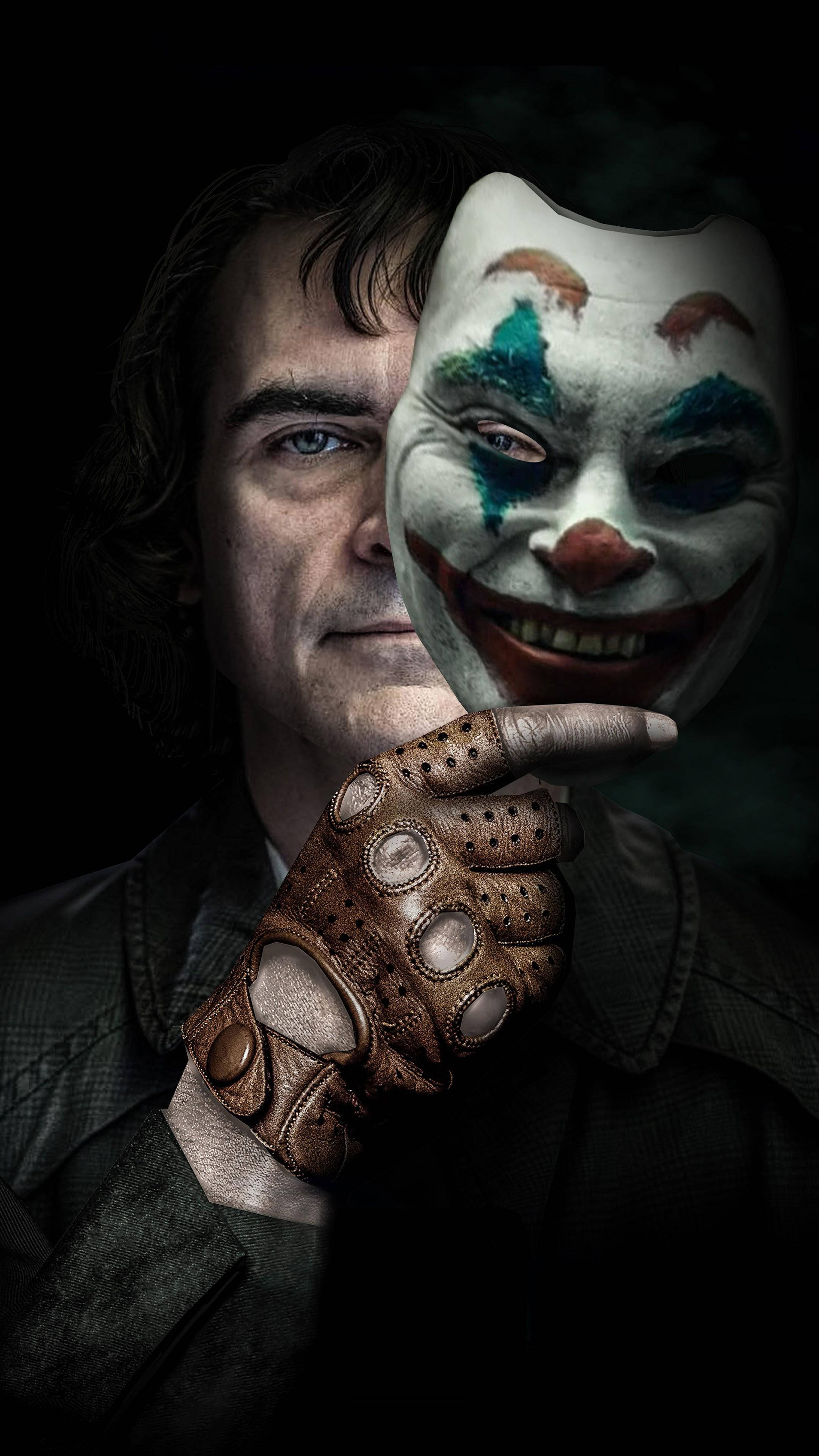 Scary Clown 桌布 壁紙 — 一個戴著皮手套的男人在黑暗背景下拿著一個彩繪小丑面具。