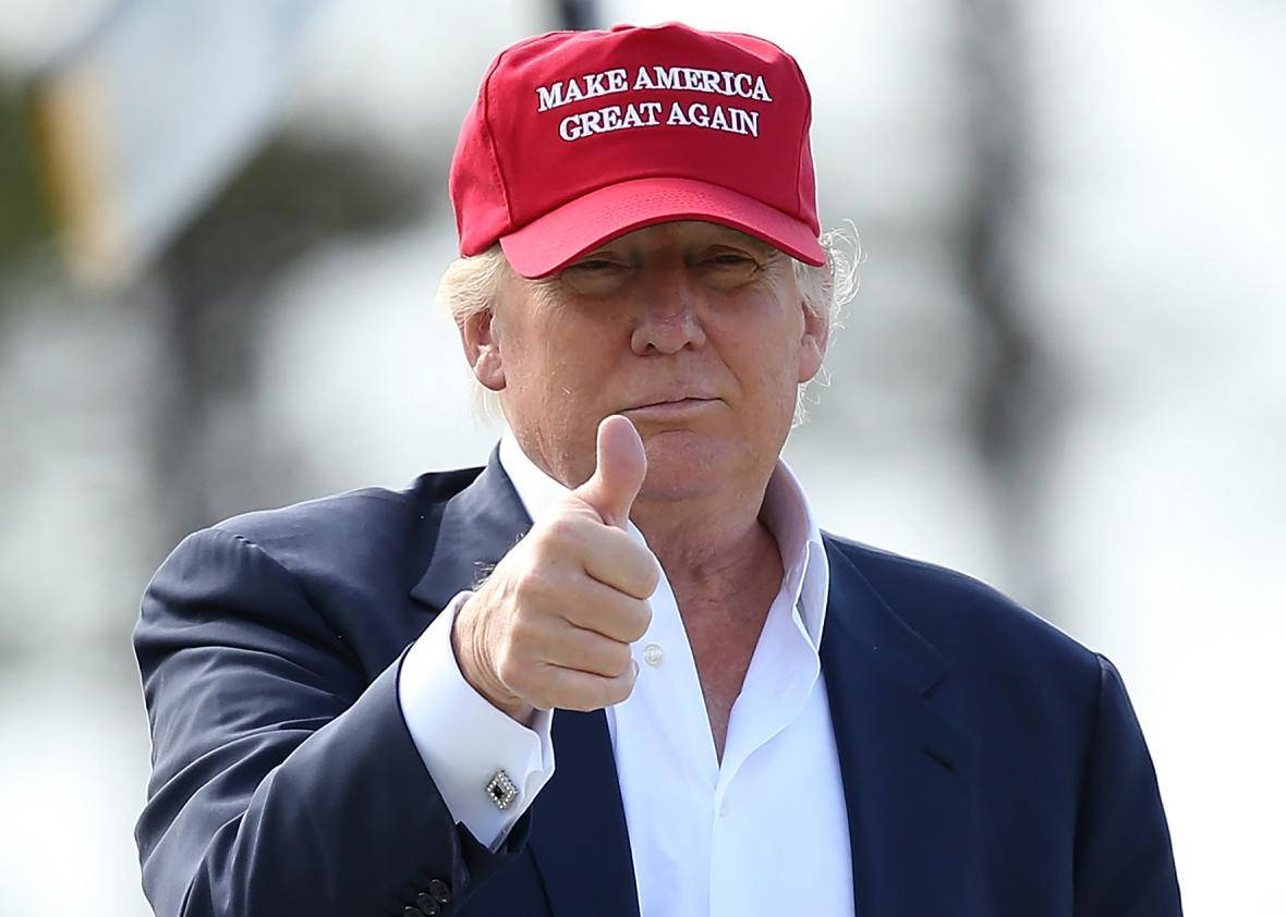 donald trump 桌布 壁紙 — 一個戴著紅色MAGA帽的男人，穿著深色西裝和白色襯衫，豎起大拇指。