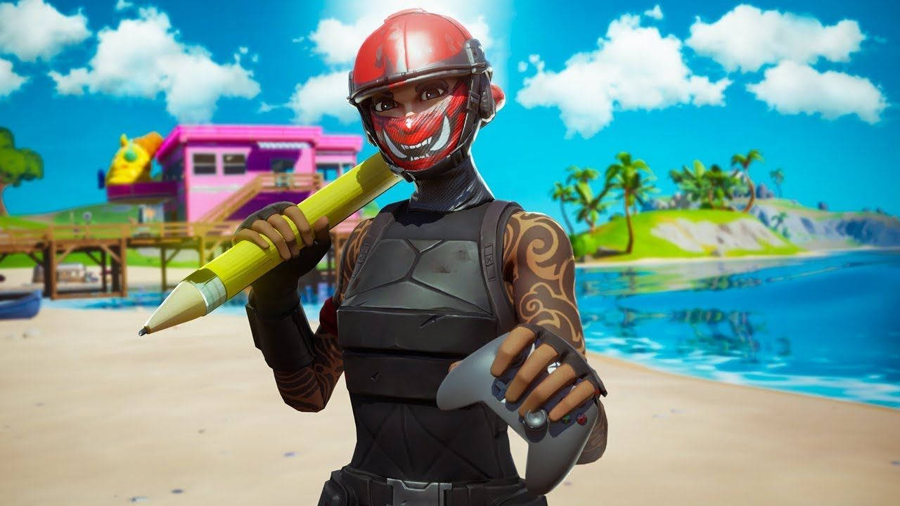 Fortnite 縮圖 桌布 壁紙 — 一個戴著紅色頭盔和面具的Fortnite角色在陽光明媚的熱帶海灘上拿著一支巨大的黃色鉛筆和遊戲控制器。