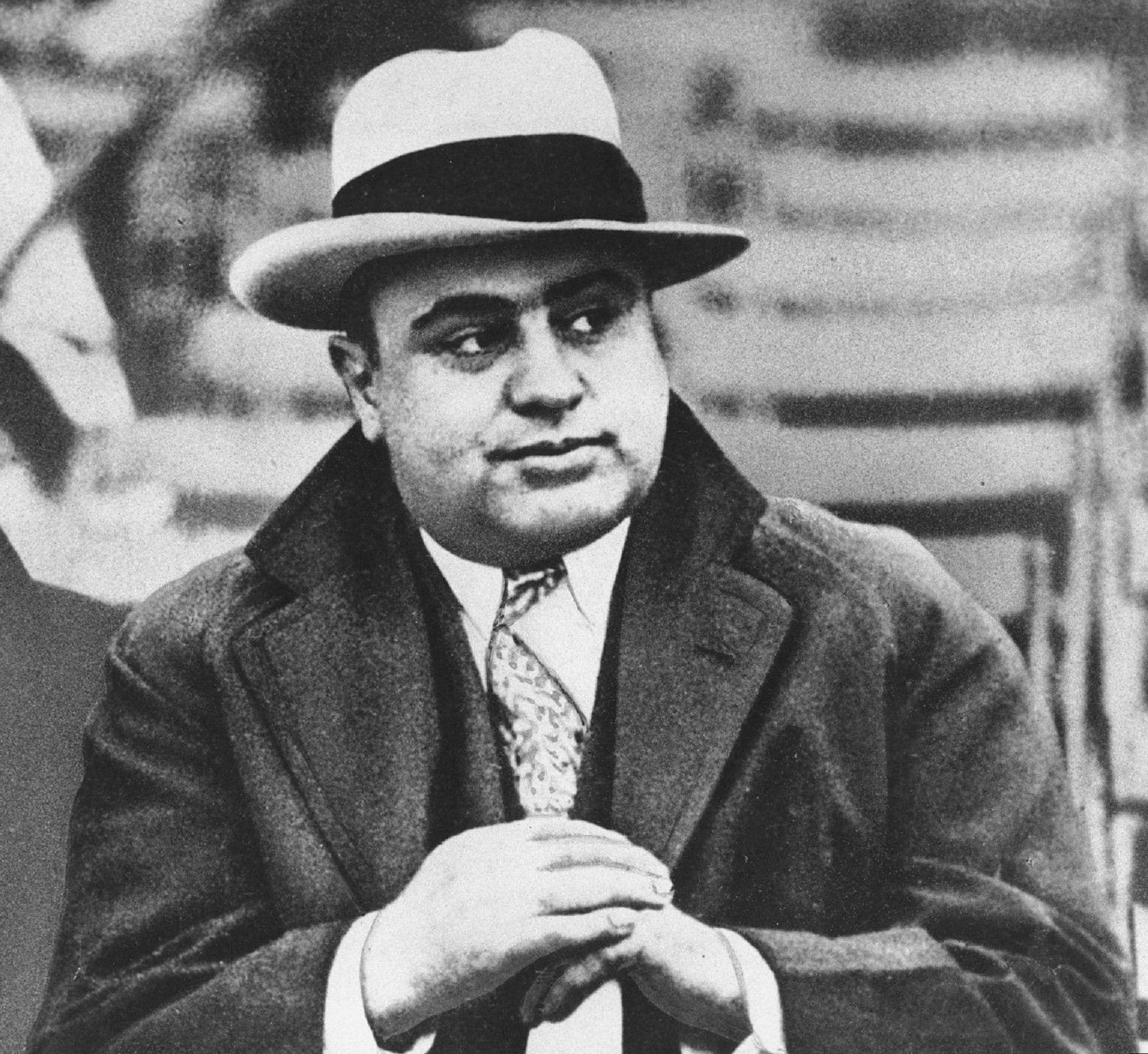 Capone 桌布 壁紙 — 一個戴著紳士帽和西裝的男人雙手交握望向一邊的黑白肖像。