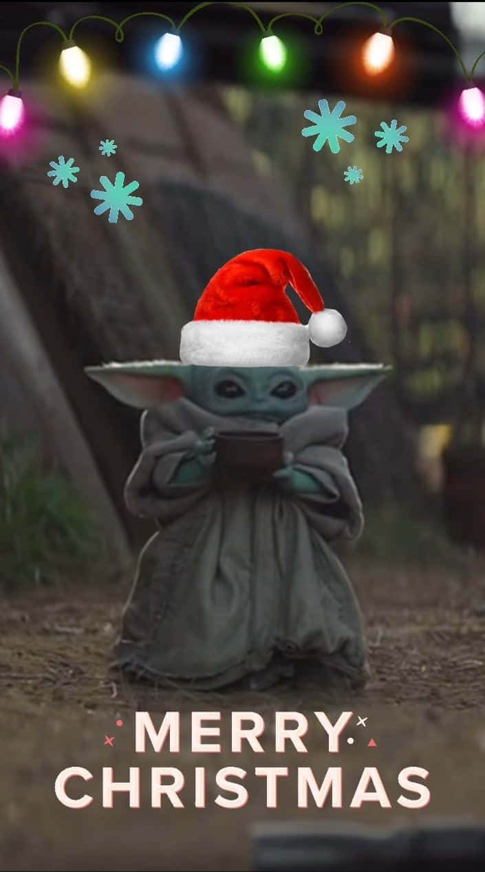 Yoda Christmas 桌布 壁紙 — 一個戴著聖誕帽的綠色小外星人，在帶有雪花圖案和「Merry Christmas」文字的彩色燈串下拿著一個杯子。