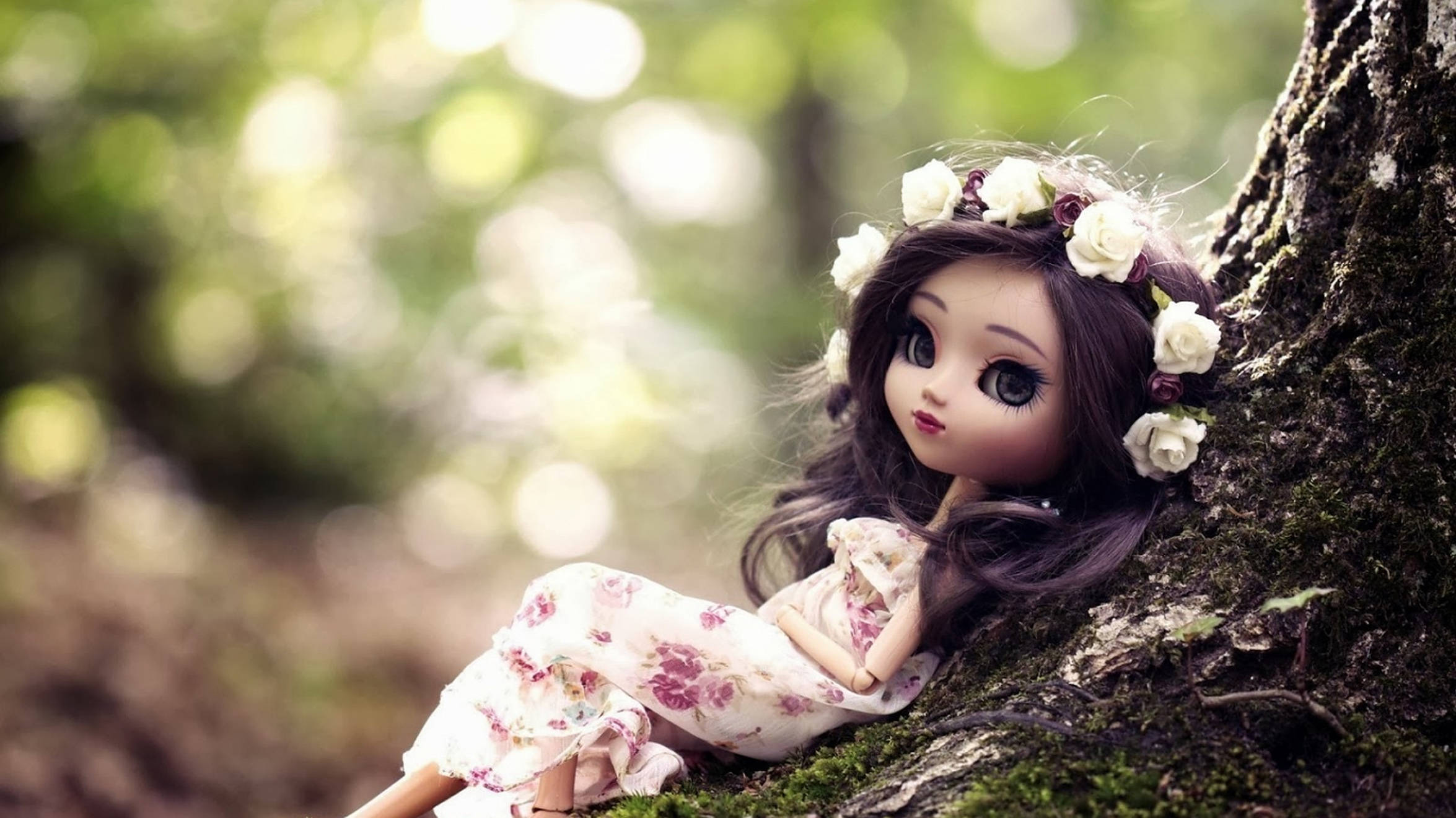 Doll 桌布 壁紙 — 一個戴著花冠和連衣裙的洋娃娃靠在陽光明媚的森林中的苔蘚樹幹上。