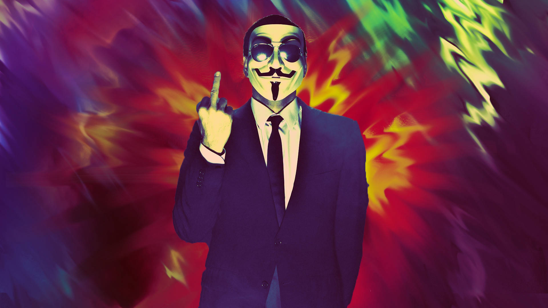 生病 桌布 壁紙 — 一個戴著蓋伊·福克斯面具和西裝的人，在紅、綠、紫三色火焰的迷幻爆炸中挑釁地豎起中指。