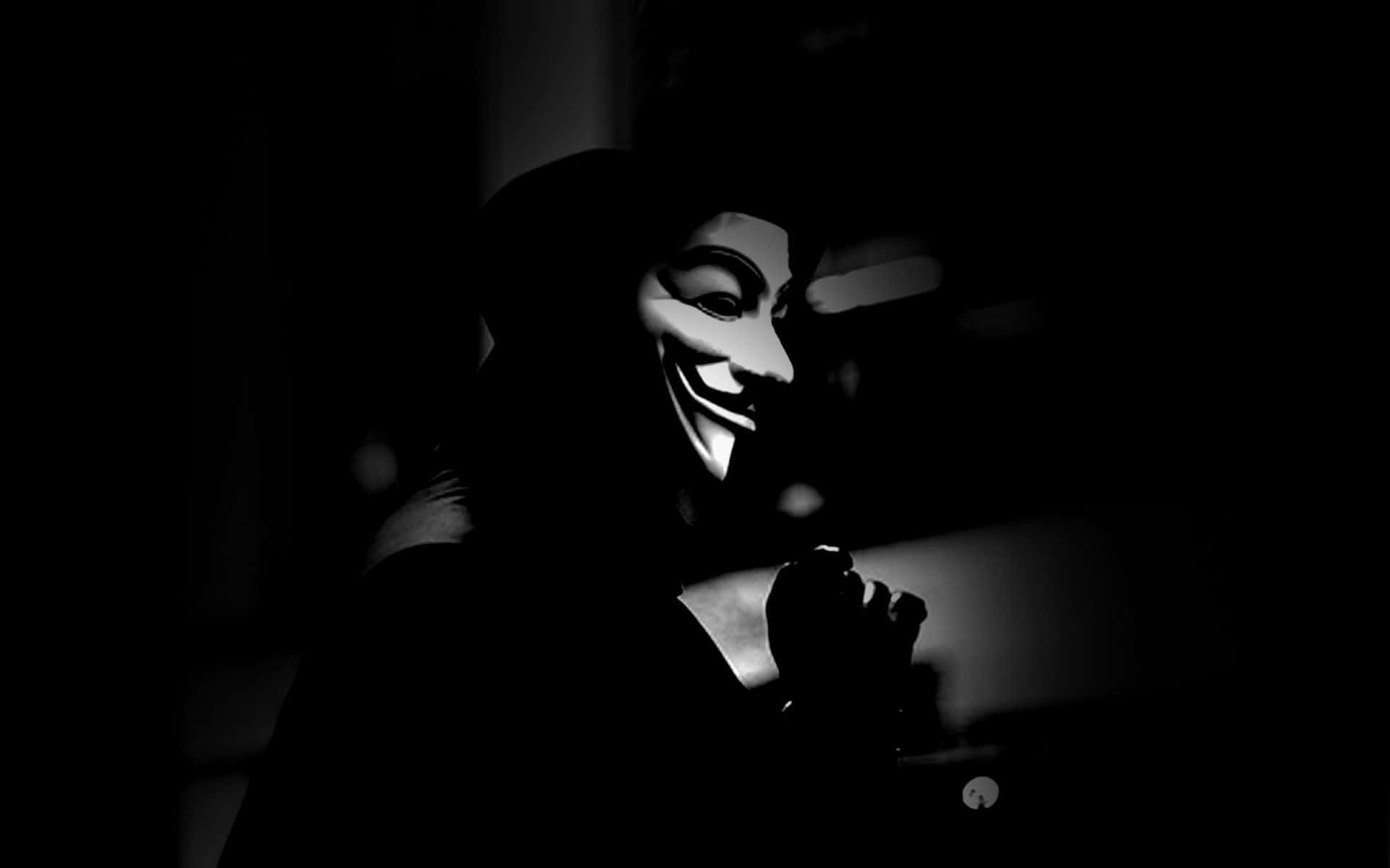 匿名 桌布 壁紙 — 一個戴著蓋伊·福克斯面具的人，在昏暗的光線下以剪影形式出現在黑暗背景前。