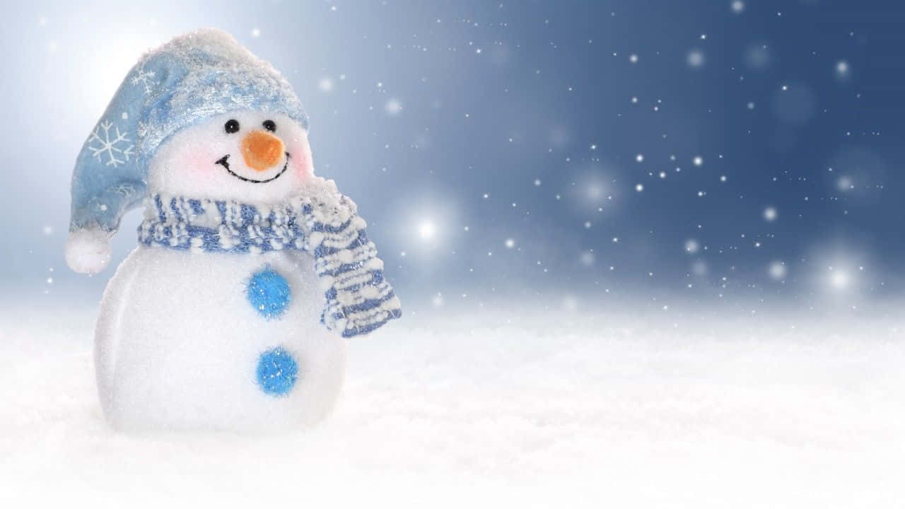 Christmas Snowman 桌布 壁紙 — 一個戴著藍色雪花帽和圍巾的快樂雪人站在飄雪的雪地上。