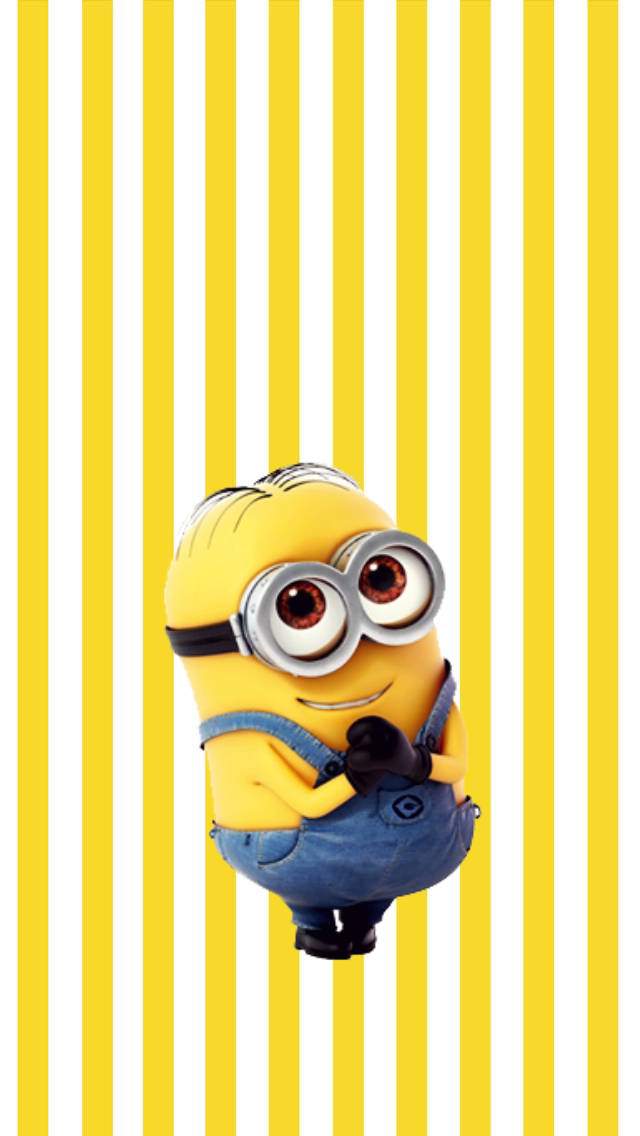 小黃人 桌布 壁紙 — 一個戴著護目鏡和工裝褲的開心黃色Minion，站在大膽的黃白條紋背景前。