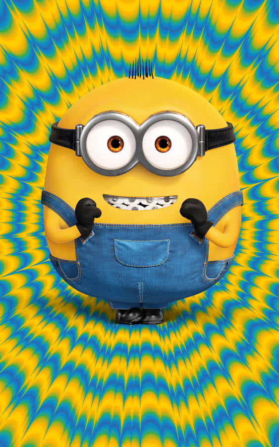 小小兵 桌布 壁紙 — 一個戴著護目鏡和牛仔布工裝褲的黃色Minion站在迷幻的藍色和黃色漩渦背景前。