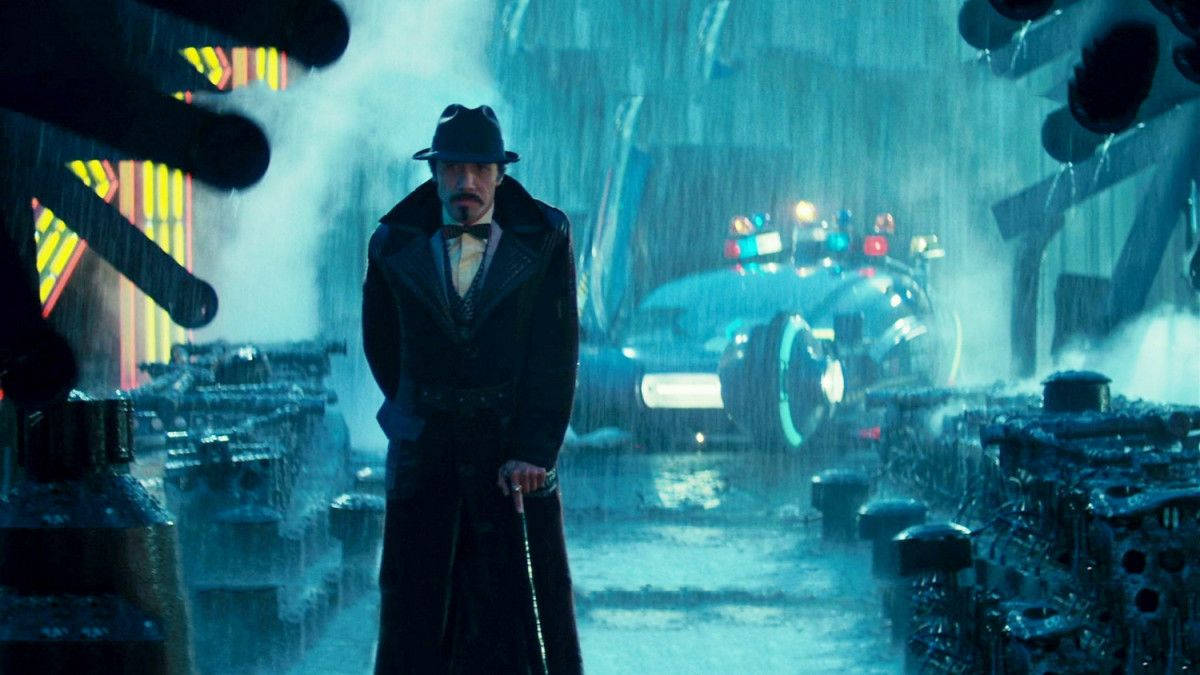 actor 桌布 壁紙 — 一個戴著費多拉帽和穿著風衣的男人站在被雨水浸濕的霓虹燈小巷中，身後有一輛未來風格的汽車。