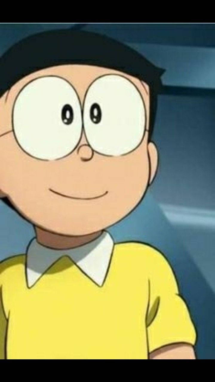 nobita 桌布 壁紙 — 一個戴著超大眼鏡、穿著黃色襯衫的開朗動畫男孩的特寫，溫暖地微笑。