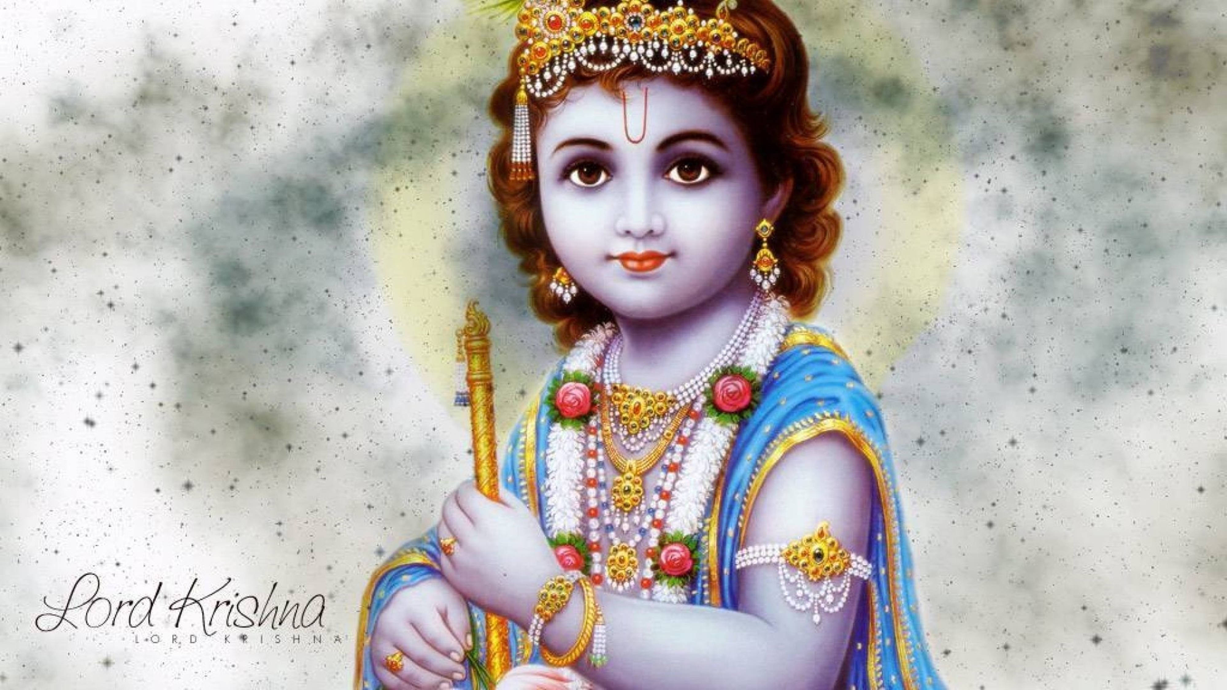 krishna god 桌布 壁紙 — 一個戴著金色皇冠、身穿藍色服飾的神聖小孩，在柔和發光的背景下手持權杖。