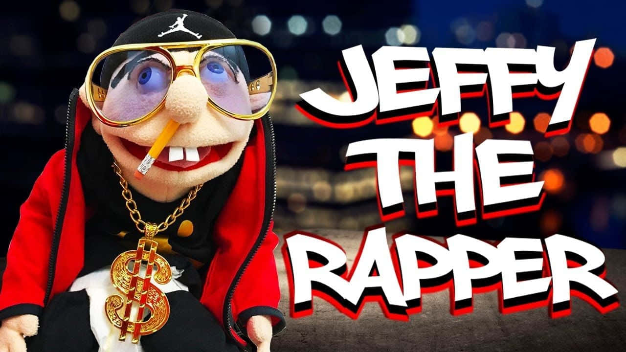 Jeffy 桌布 壁紙 — 一個戴著金邊眼鏡和掛著美元符號鏈條的木偶，在模糊的城市夜景背景下像說唱歌手一樣擺姿勢。