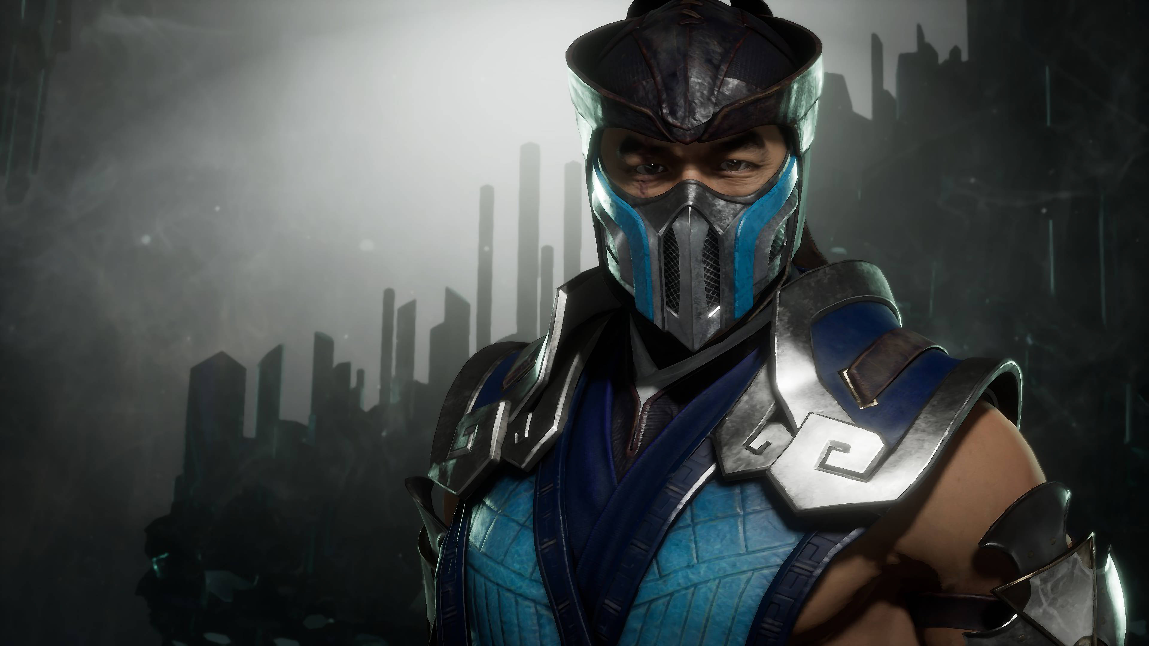 Sub-zero 桌布 壁紙 — 一個戴著面具的戰士，身穿藍色和銀色盔甲，挑釁地站在霧氣瀰漫的未來城市天際線前。
