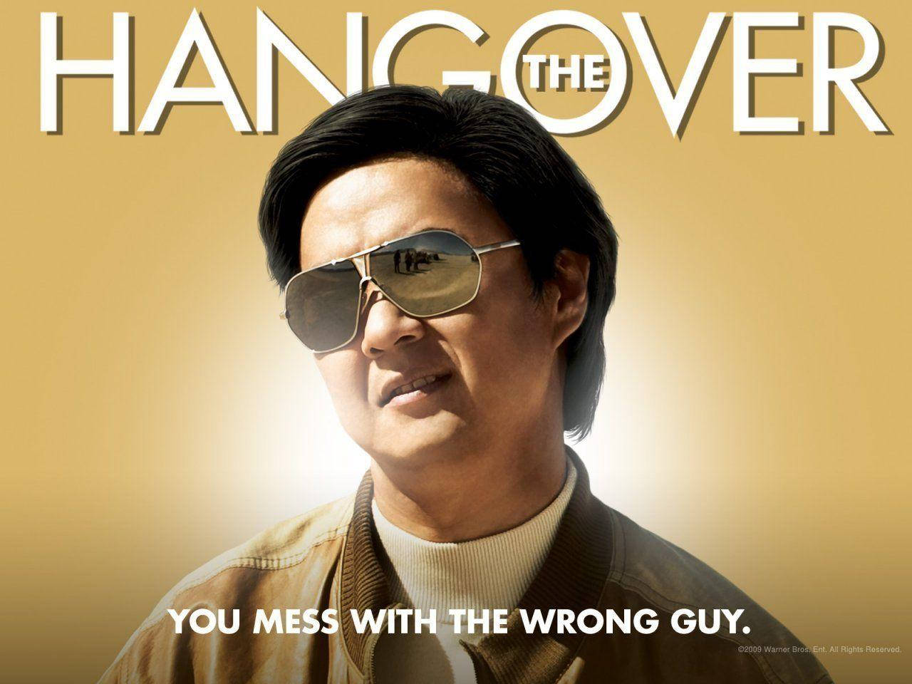 leslie chow 桌布 壁紙 — 一個戴著飛行員太陽眼鏡的男人，在金色漸層背景上自信地咧嘴笑，並帶有粗體電影標題文字。
