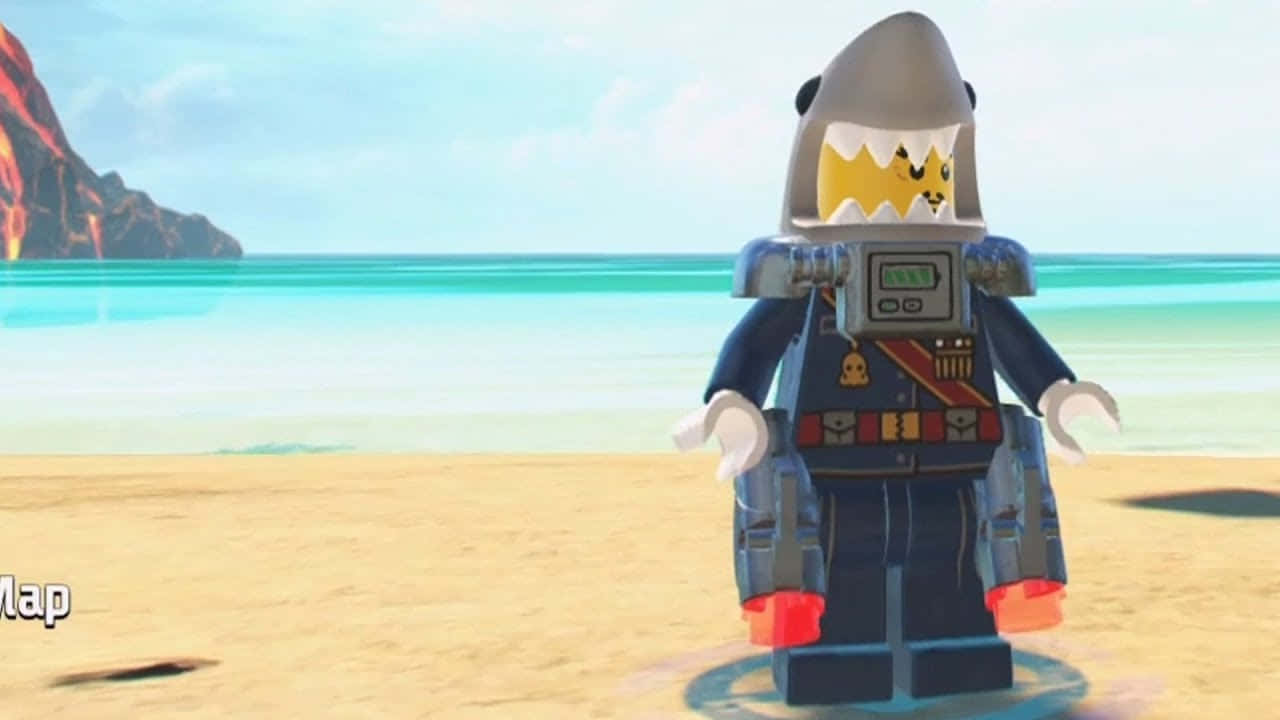 樂高 桌布 壁紙 — 一個戴著鯊魚頭盔的LEGO迷你人偶站在沙灘上，面向遠處有火山懸崖的碧綠海洋。