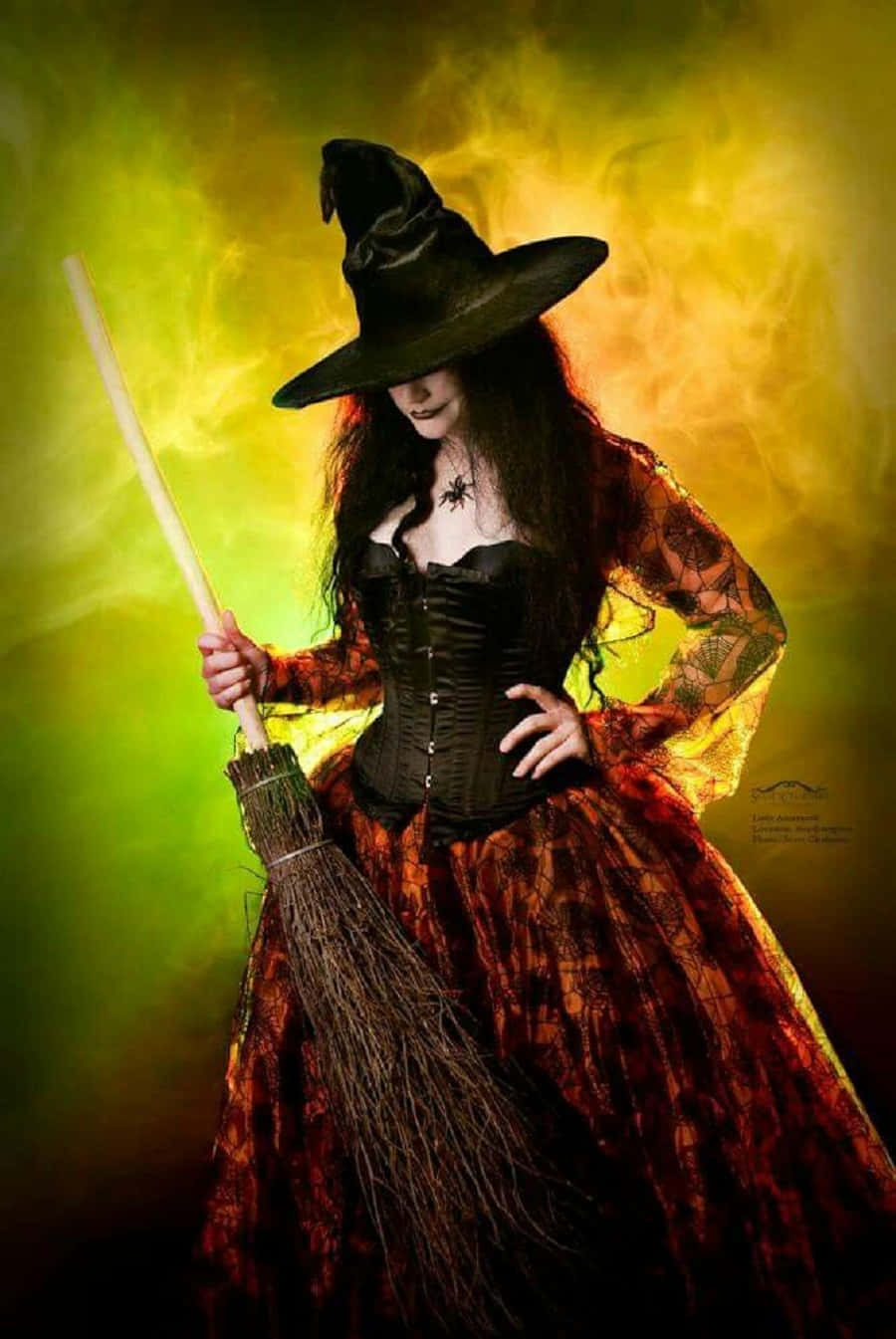 Witch Costumes 桌布 壁紙 — 一個戴著黑色帽子和束腰長袍的女巫，手持掃帚，背景是旋轉的綠色和黃色神秘背景。