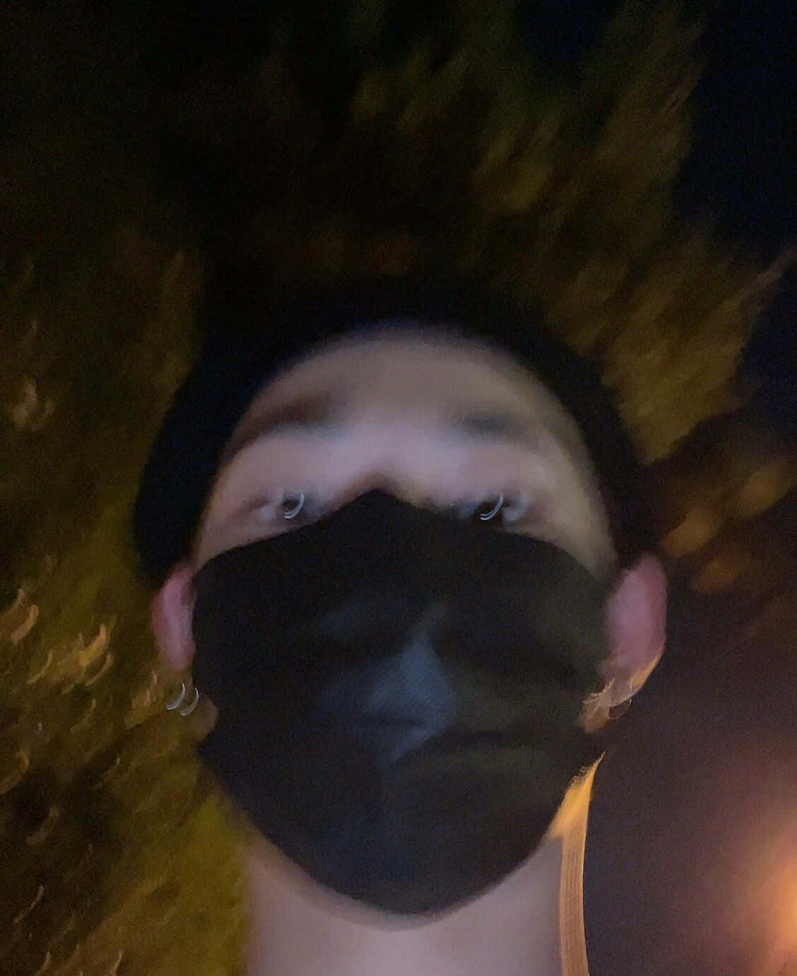 Mask 桌布 壁紙 — 一個戴著黑色面罩和毛帽的人，在夜晚模糊的金色背景下，用發光的眼睛望向鏡頭。