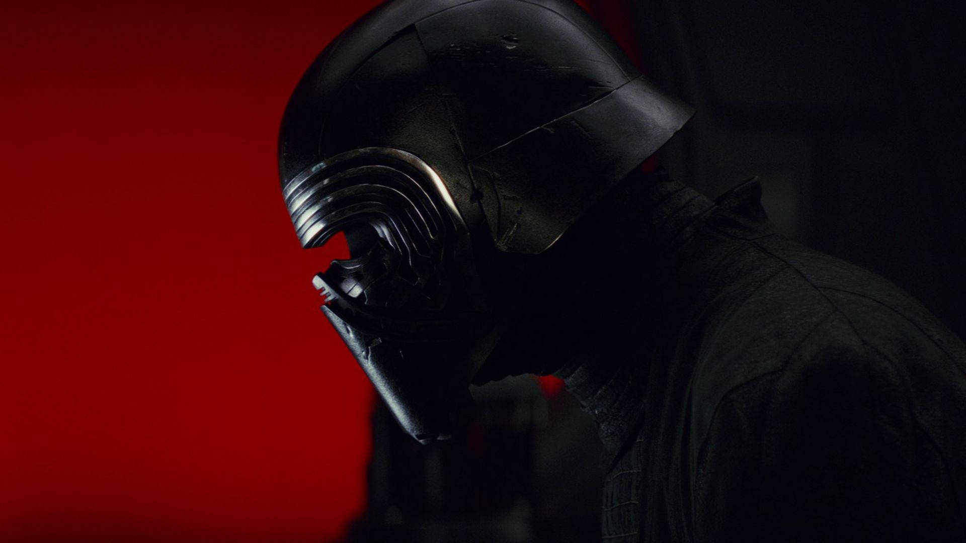 Kylo Ren 桌布 壁紙 — 一個戴著黑色頭盔的威脅人物站在陰影中，背景是鮮豔的紅色。