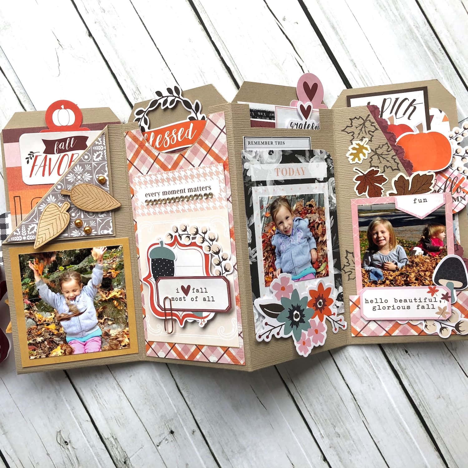 Scrapbooking 桌布 壁紙 — 一個手工製作的秋季剪貼簿跨頁，包含孩子們在落葉中玩耍的照片和裝飾性秋季元素，放置在經風化的木質表面上。