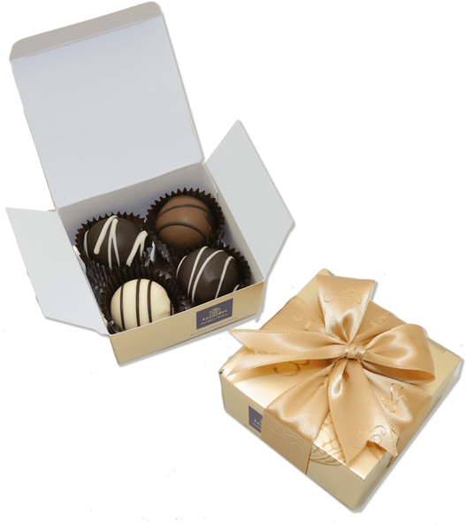 巧克力 桌布 壁紙 — 一個打開的奶油色盒子露出各種淋上白巧克力的松露巧克力，旁邊是一個用緞帶蝴蝶結繫著的關閉盒子。