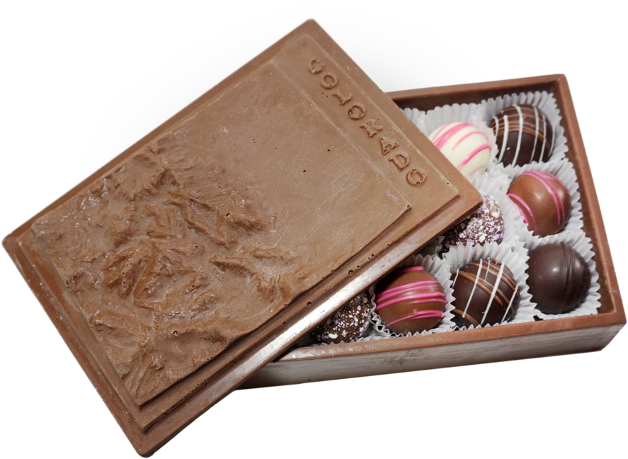 Chocolate 桌布 壁紙 — 一個打開的巧克力盒展示各種松露巧克力，上面有粉紅色淋面和彩針，放在白色紙杯中。