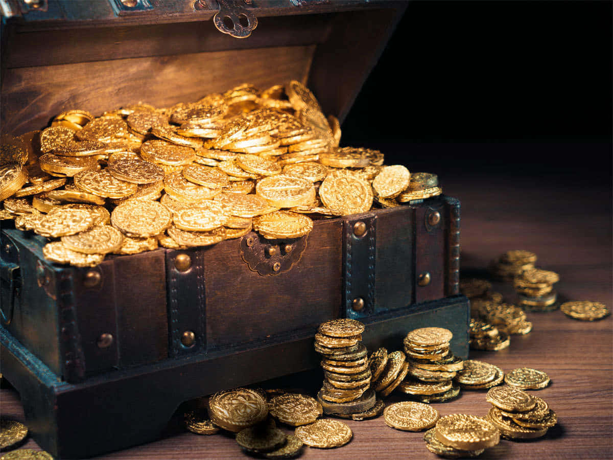 Coin 桌布 壁紙 — 一個打開的木製寶箱，裝滿閃閃發光的金幣，灑落在深色木質表面上。