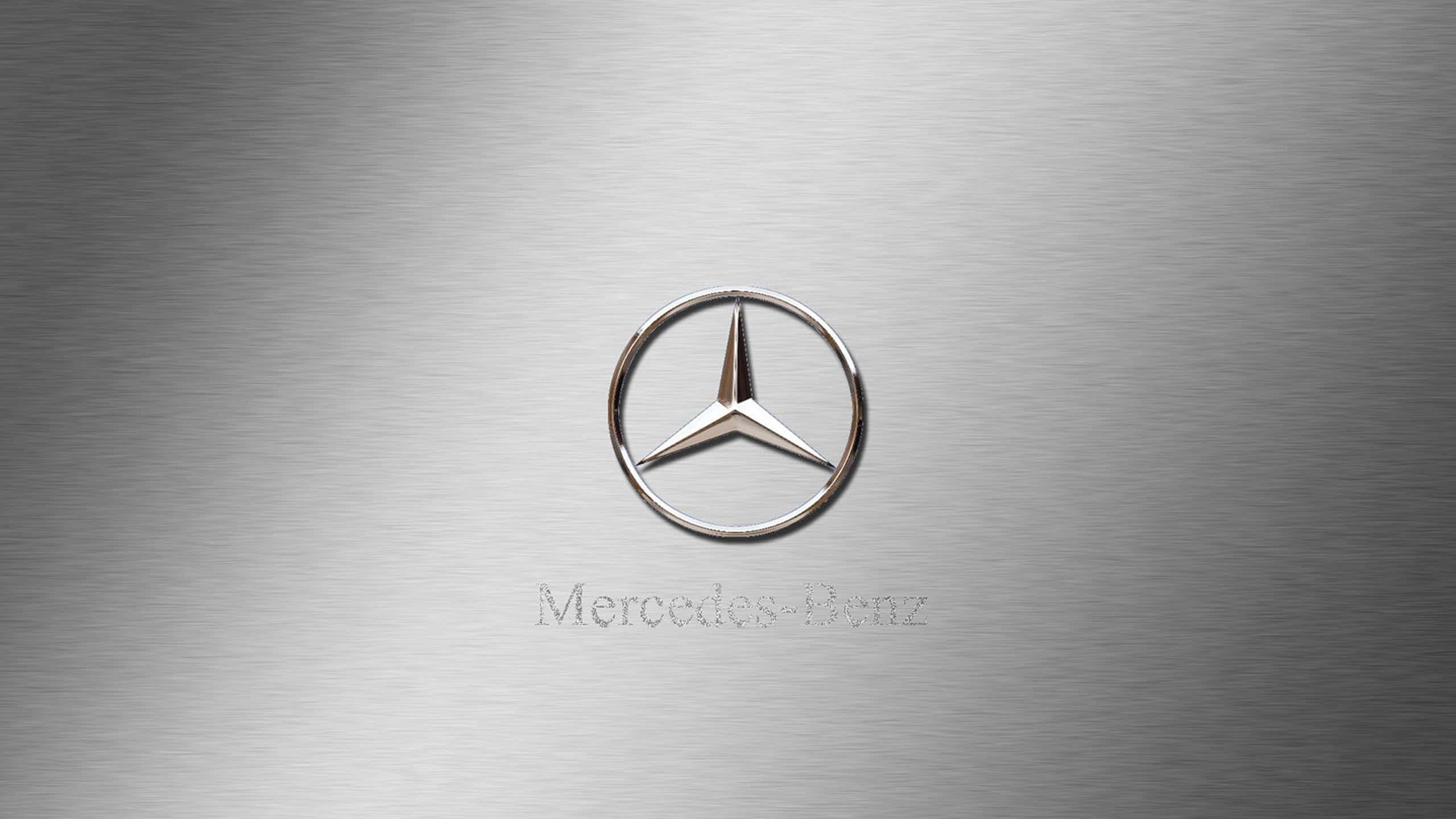 Mercedes Benz Logo 桌布 壁紙 — 一個拋光銀色 Mercedes-Benz 標誌，居中於拉絲金屬背景上，帶有微妙的燈光反射。