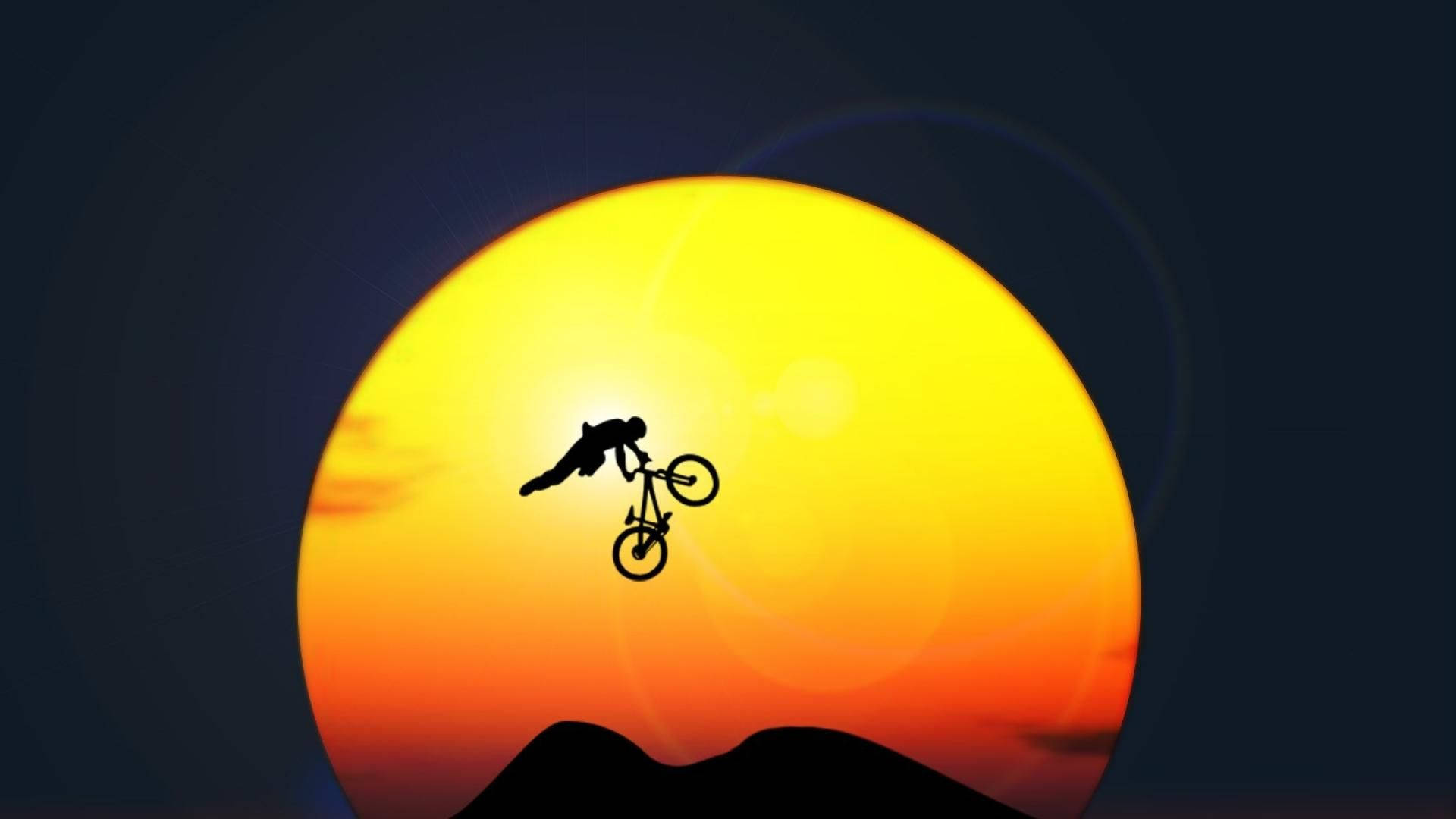 bike riding 桌布 壁紙 — 一個摩托車手的剪影在山峰上巨大的發光日落前表演空中特技。