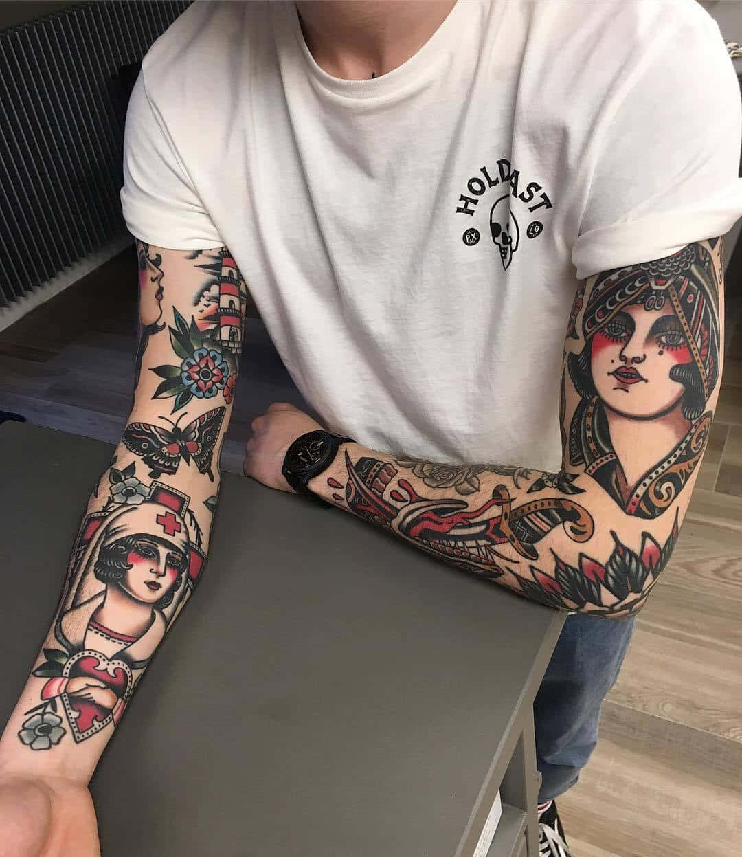 Tattoo Boy 桌布 壁紙 — 一個擁有全袖刺青的人，上面有復古護士和女性肖像，帶有花卉和蝴蝶圖案。