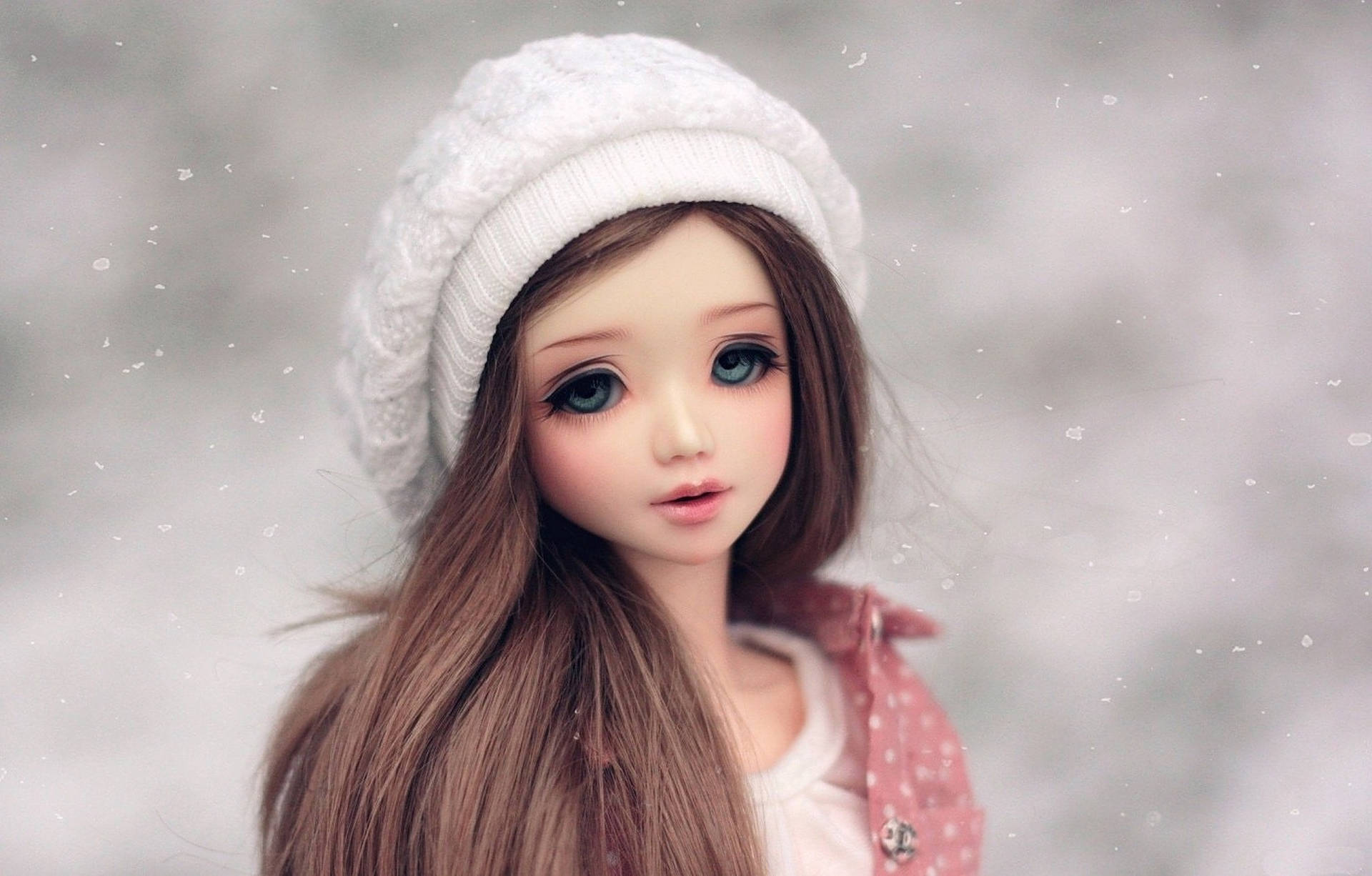 Doll 桌布 壁紙 — 一個擁有大藍眼睛和長棕髮的玩偶，在雪景背景下戴著白色針織帽。