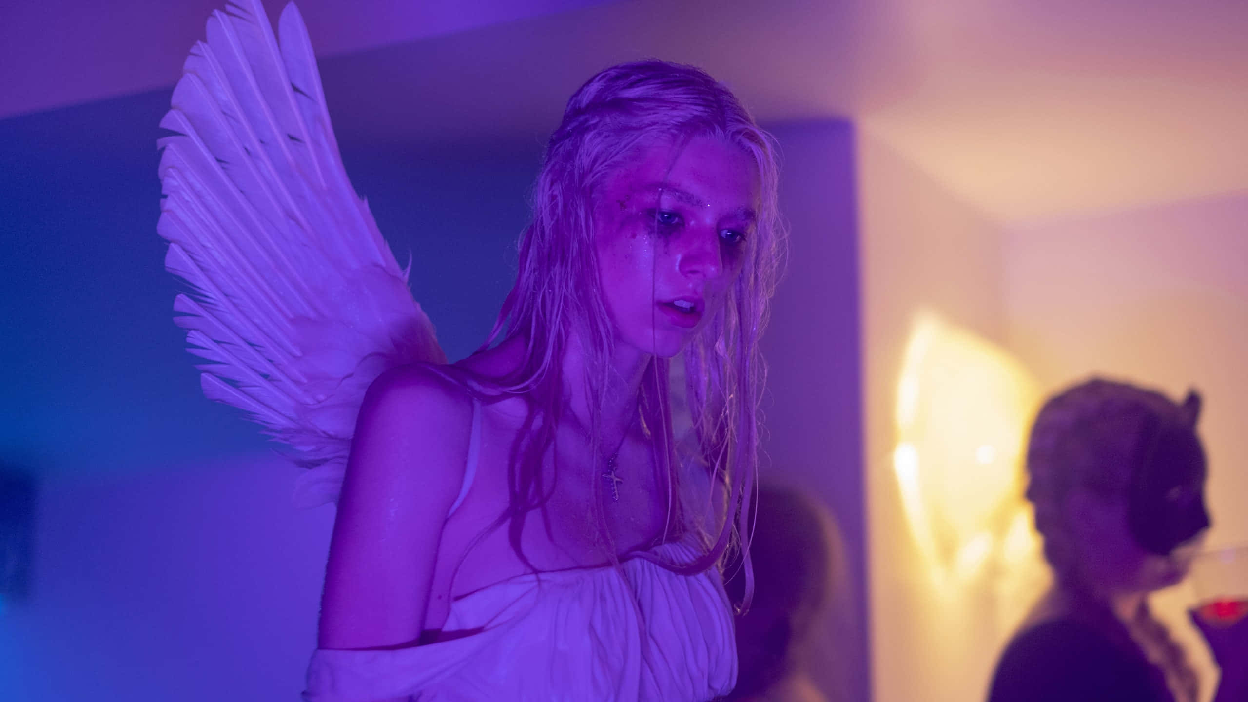 Euphoria Hbo iPhone 桌布 壁紙 — 一個擁有天使翅膀和濕頭髮的人站在一個昏暗的房間裡，沐浴在紫色和橙色的光芒中。