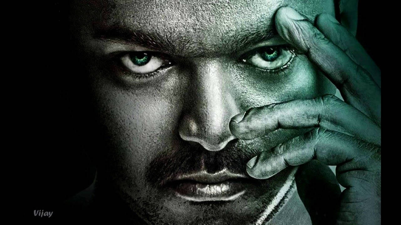 Bollywood HD 桌布 壁紙 — 一個擁有強烈綠色眼睛的男人直視觀眾，他的手在黑暗背景下遮住半張臉。