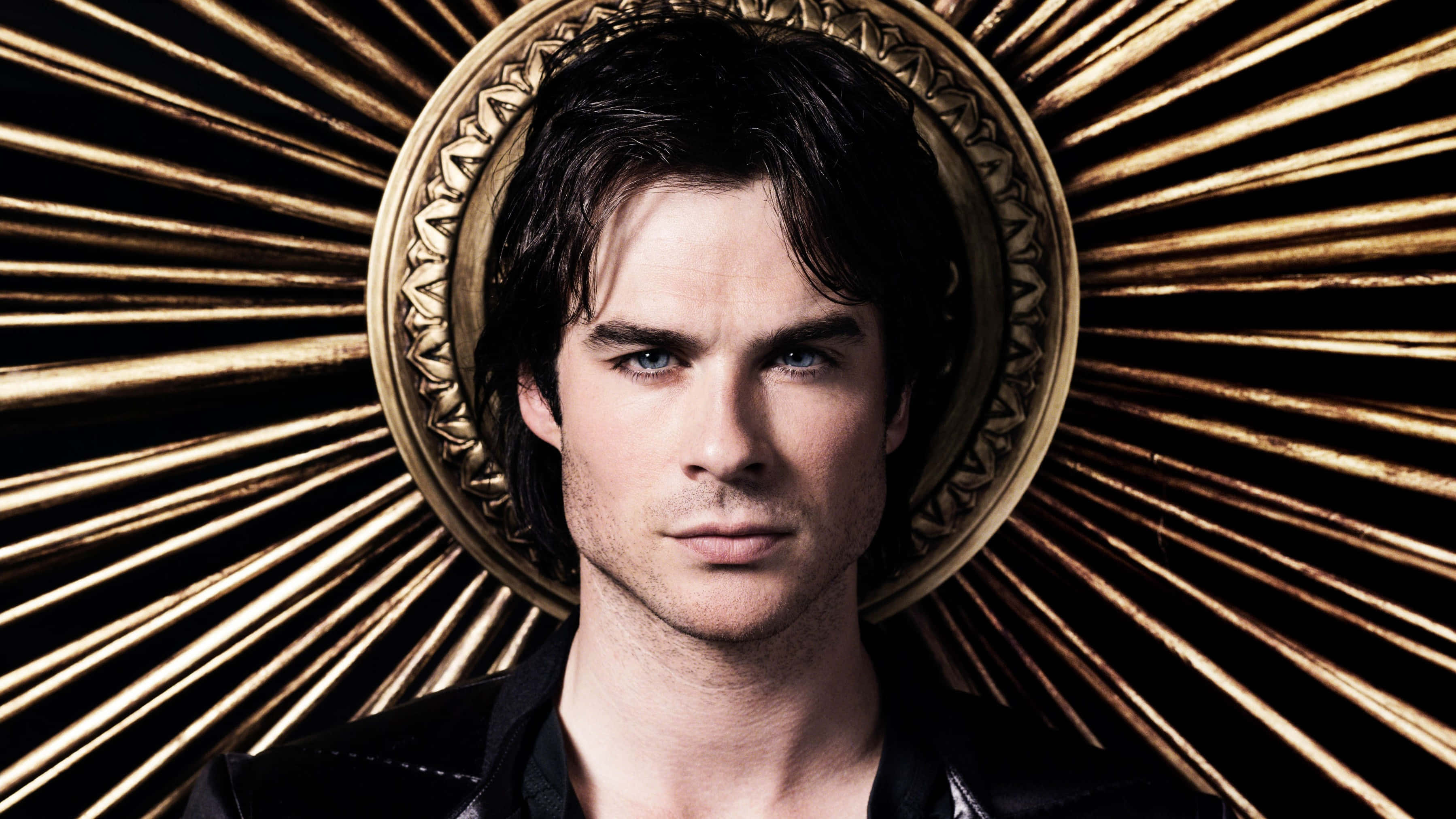 Vampire Diaries Desktop 桌布 壁紙 — 一個擁有強烈藍色眼睛的男人向前凝視，被金色華麗光環框住，背景是燦爛的太陽光芒。