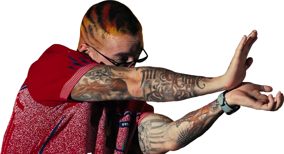 綠洲 桌布 壁紙 — 一個擁有彩色頭髮和紋身手臂的男人在黑色背景前做手勢，穿著紅色圖案襯衫。